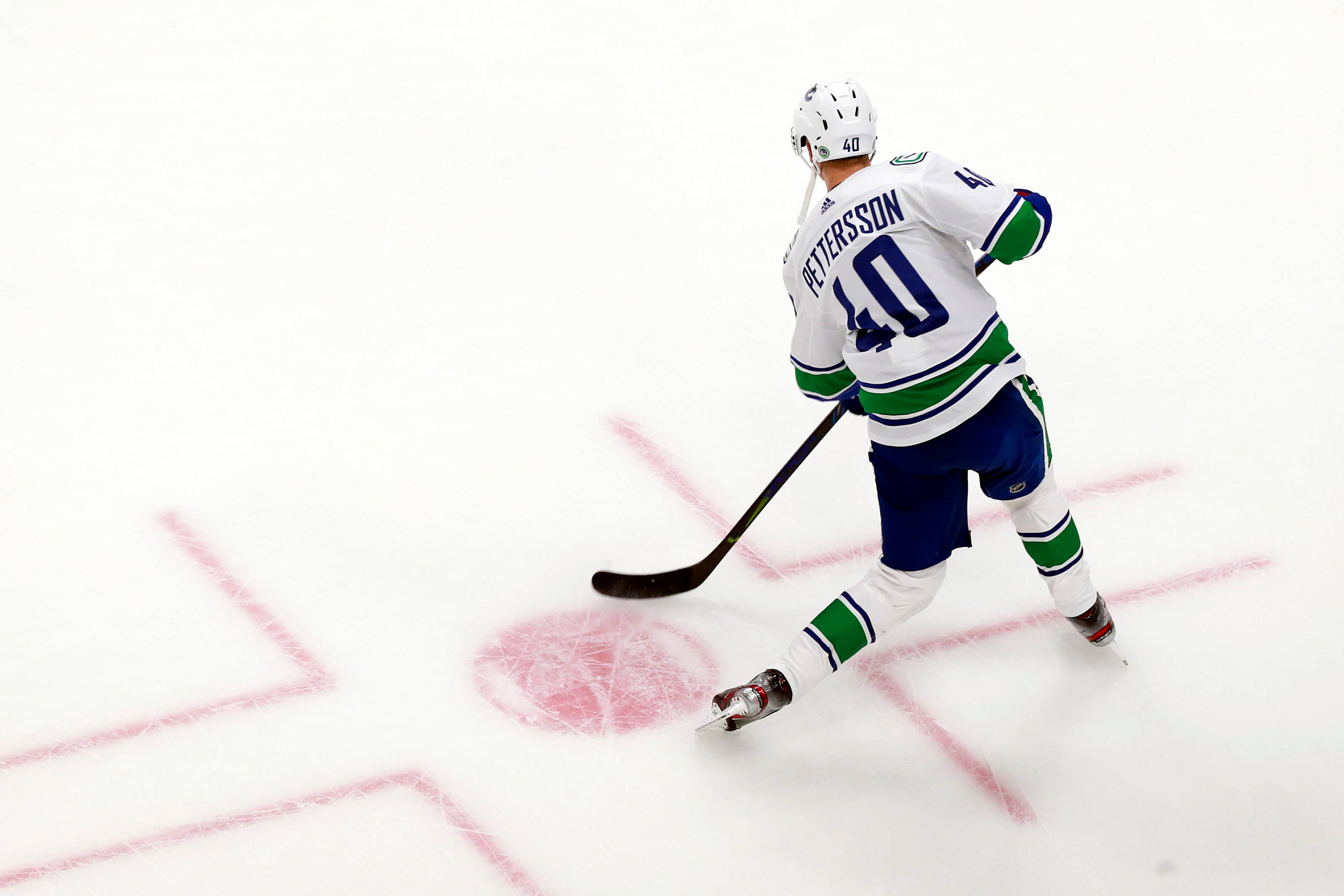 hockey 桌布 壁紙 — 冰球運動員40號在明亮的場館燈光下，在比賽中帶著冰球在冰上滑行。