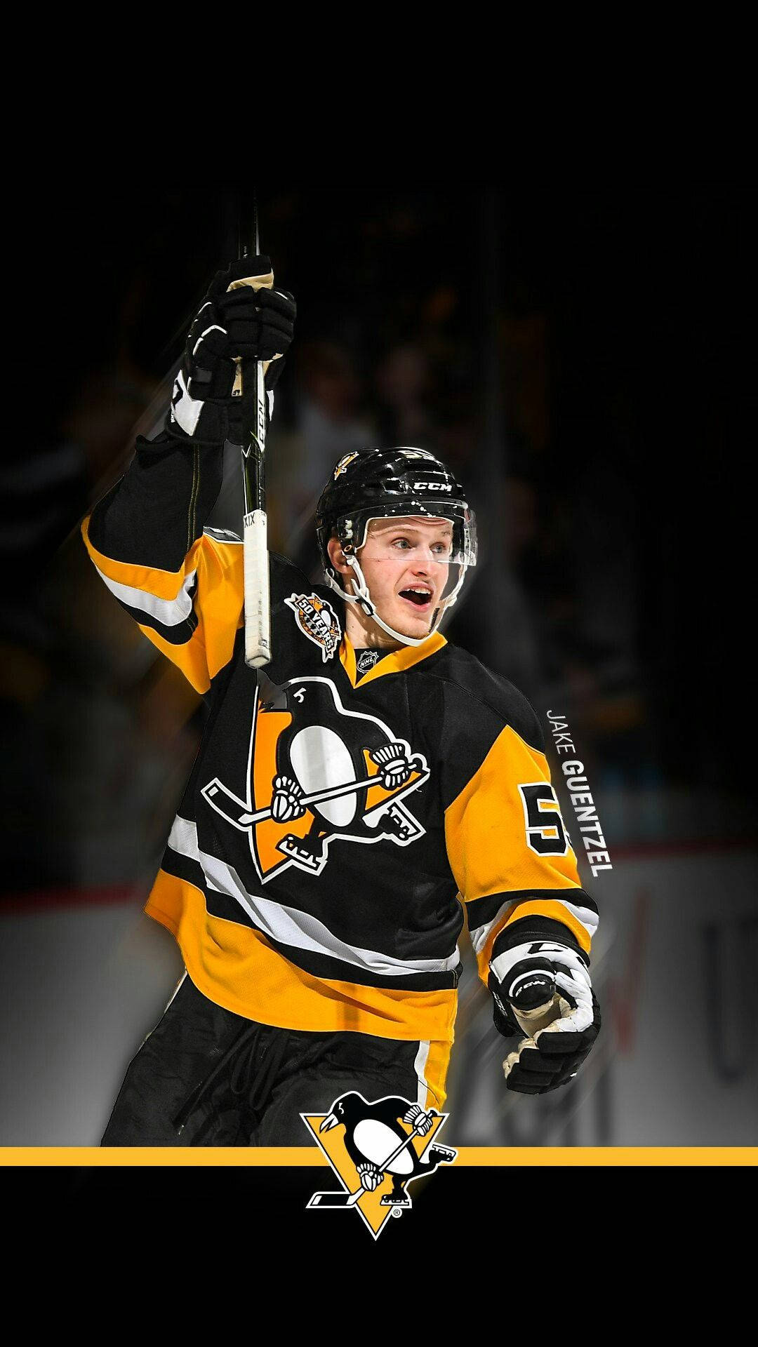 hockey 桌布 壁紙 — 冰球運動員Jake Guentzel身穿黑金企鵝隊球衣，在場館燈光下高舉球棍慶祝。