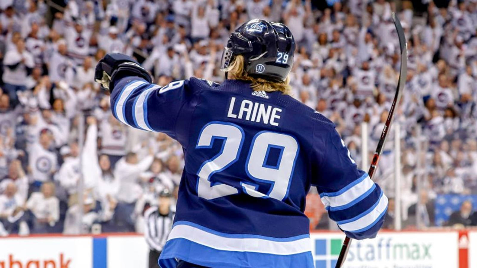 運動 桌布 壁紙 — 冰球運動員Laine（29號）在場館內高舉手套，面對歡呼的人群慶祝。