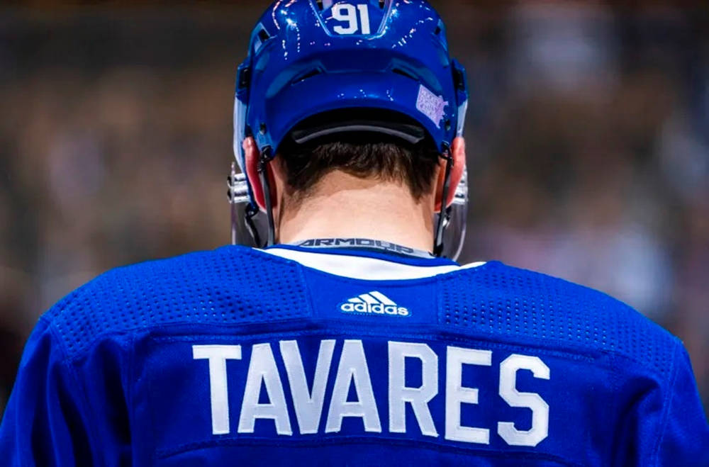 運動 桌布 壁紙 — 冰球運動員背部特寫，身穿藍色球衣，可見'TAVARES'和91號。