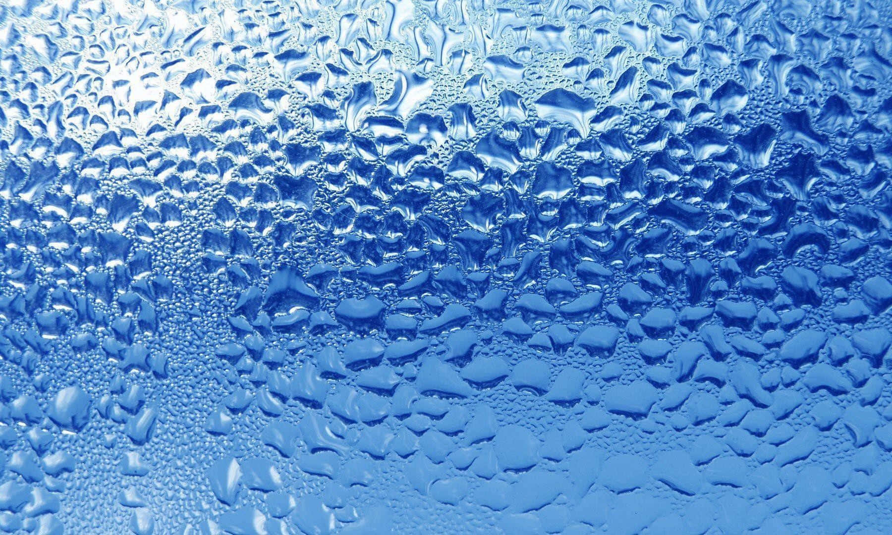 3d Water 桌布 壁紙 — 冰藍色表面上閃閃發光的水滴特寫，形成帶有紋理和反射效果的圖案。