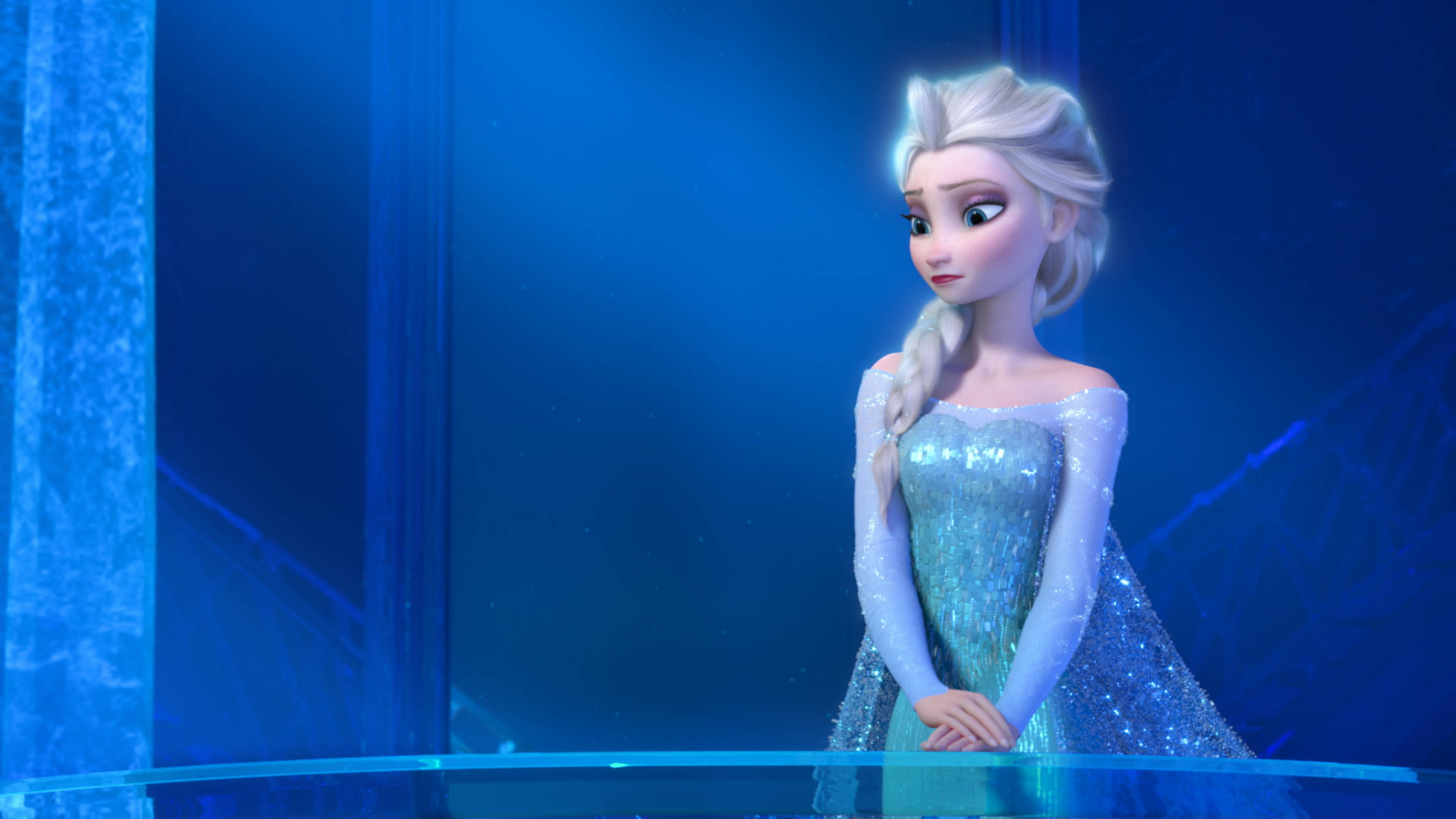 Frozen Elsa 桌布 壁紙 — 《冰雪奇緣》中的艾莎身穿閃爍冰裙，在深藍水晶背景前擺好姿勢。