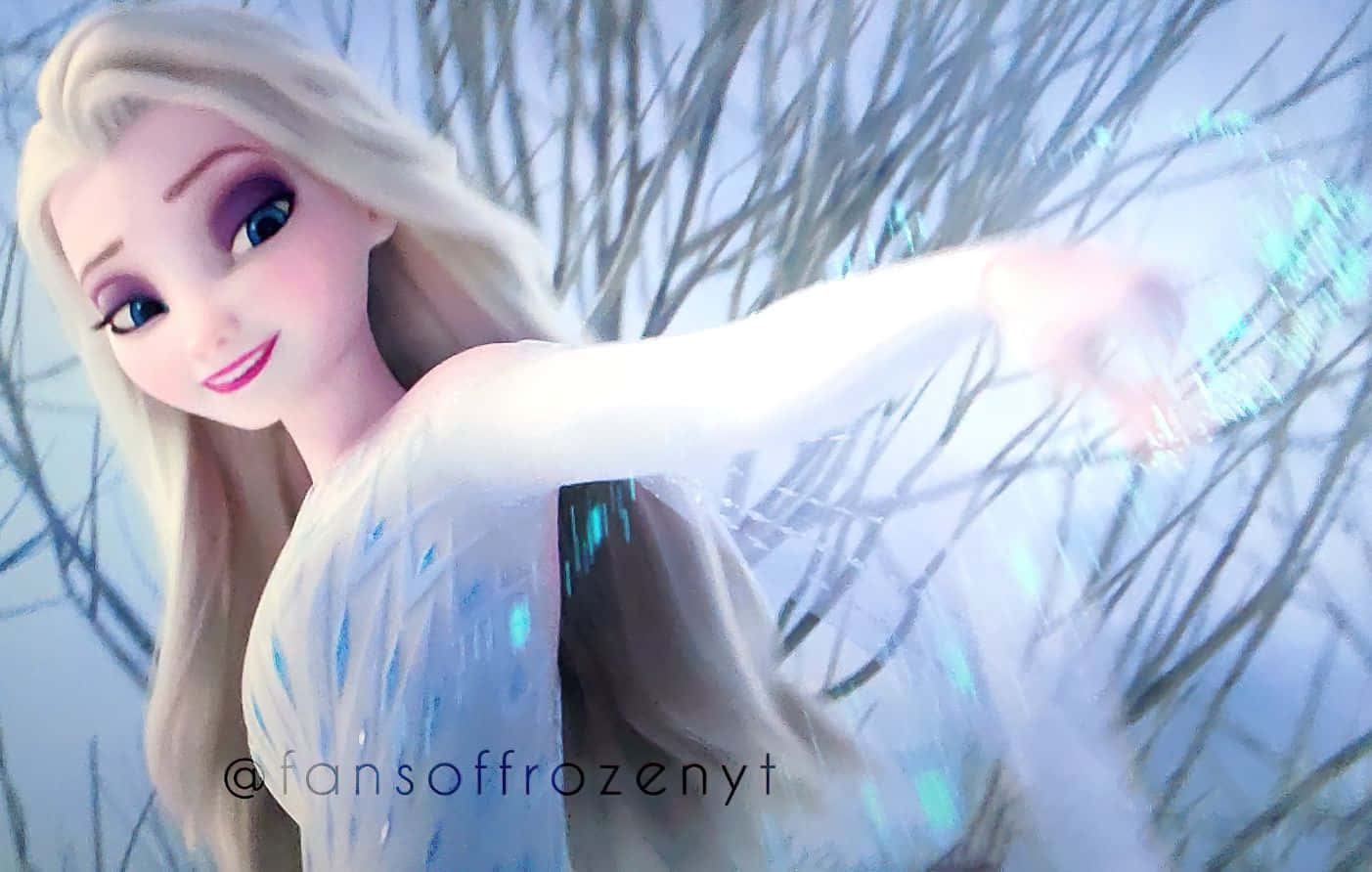 桌布 壁紙 — 《冰雪奇緣》的艾莎伸出手，在柔和的藍光下穿過光禿的冬季樹枝施展冰魔法。