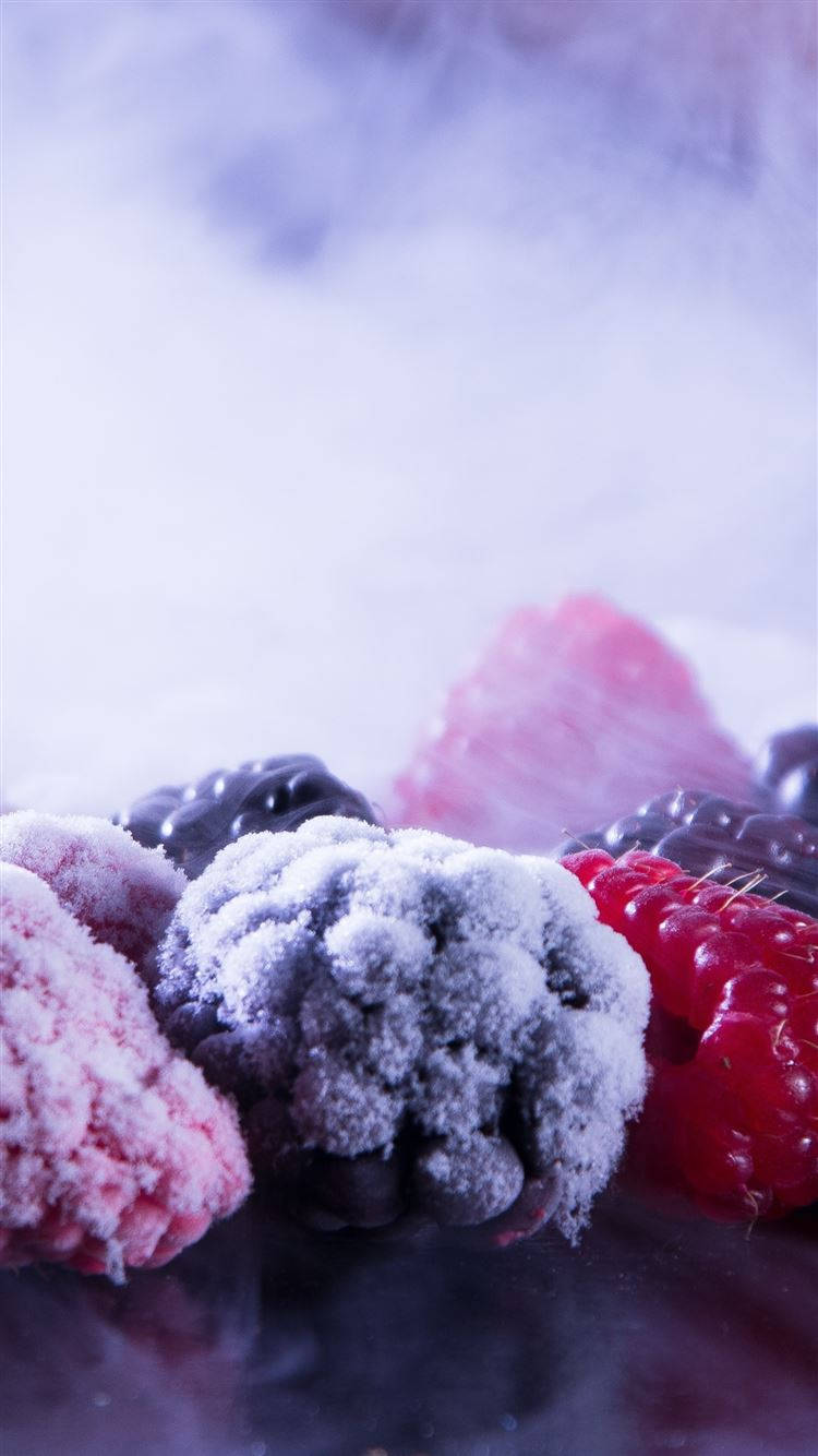Fruit 桌布 壁紙 — 冷凍莓果覆蓋著霜，在冷紫色燈光下閃耀，背景有霧氣旋轉。