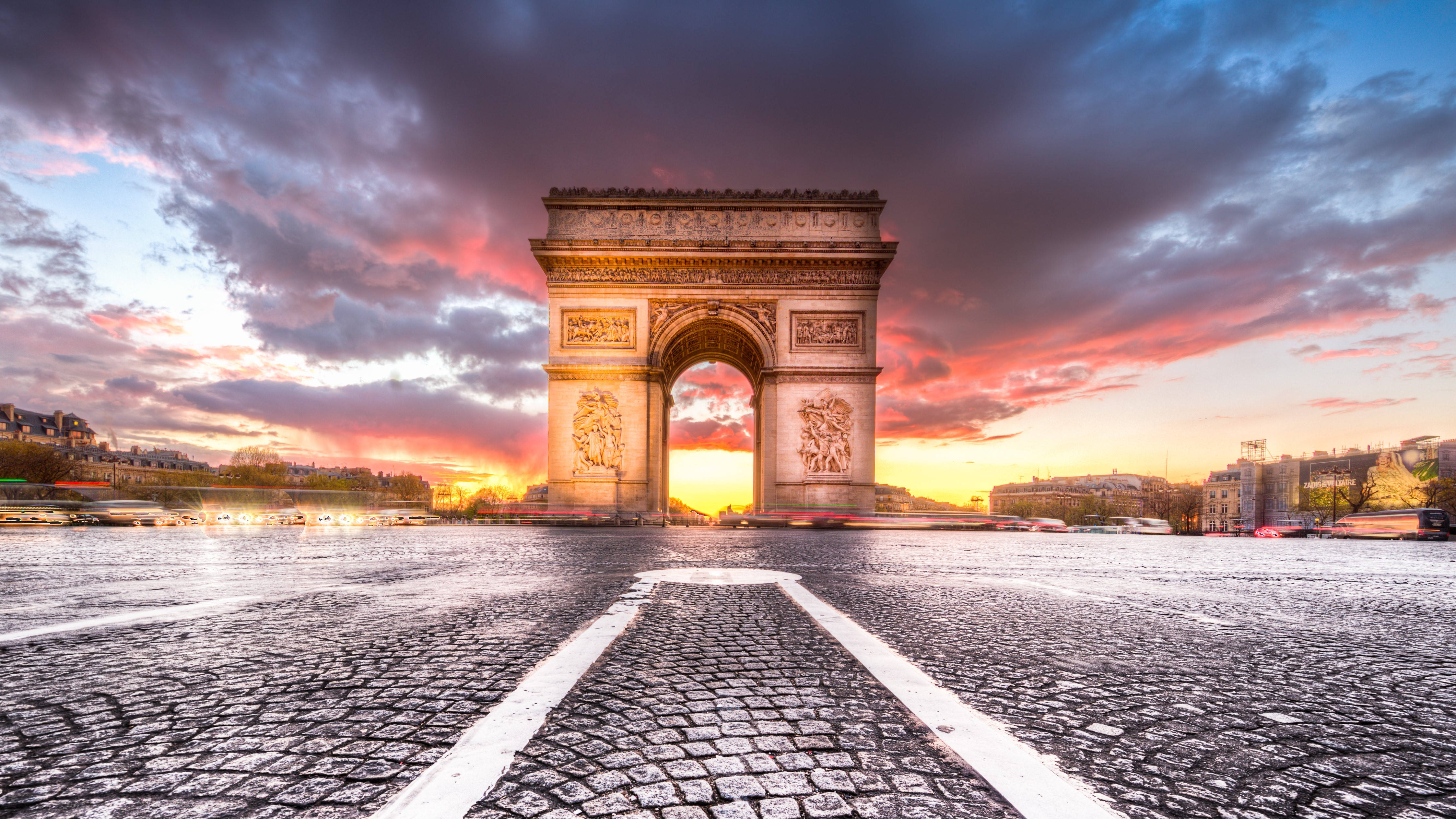 France 桌布 壁紙 — 凱旋門在戲劇性的日落天空下巍然聳立，下方車流如織。