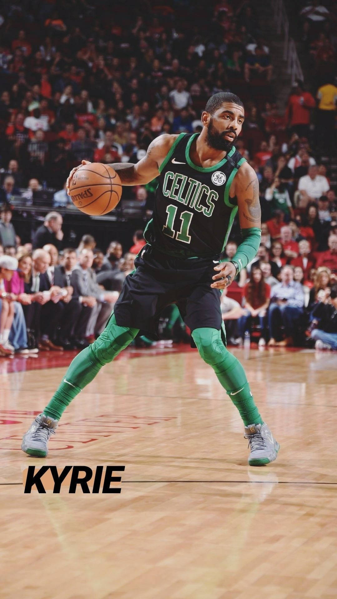 Kyrie 桌布 壁紙 — 凱里·厄文身穿綠色塞爾提克球衣，在比賽中專注地運球，面對熱情沸騰的觀眾。