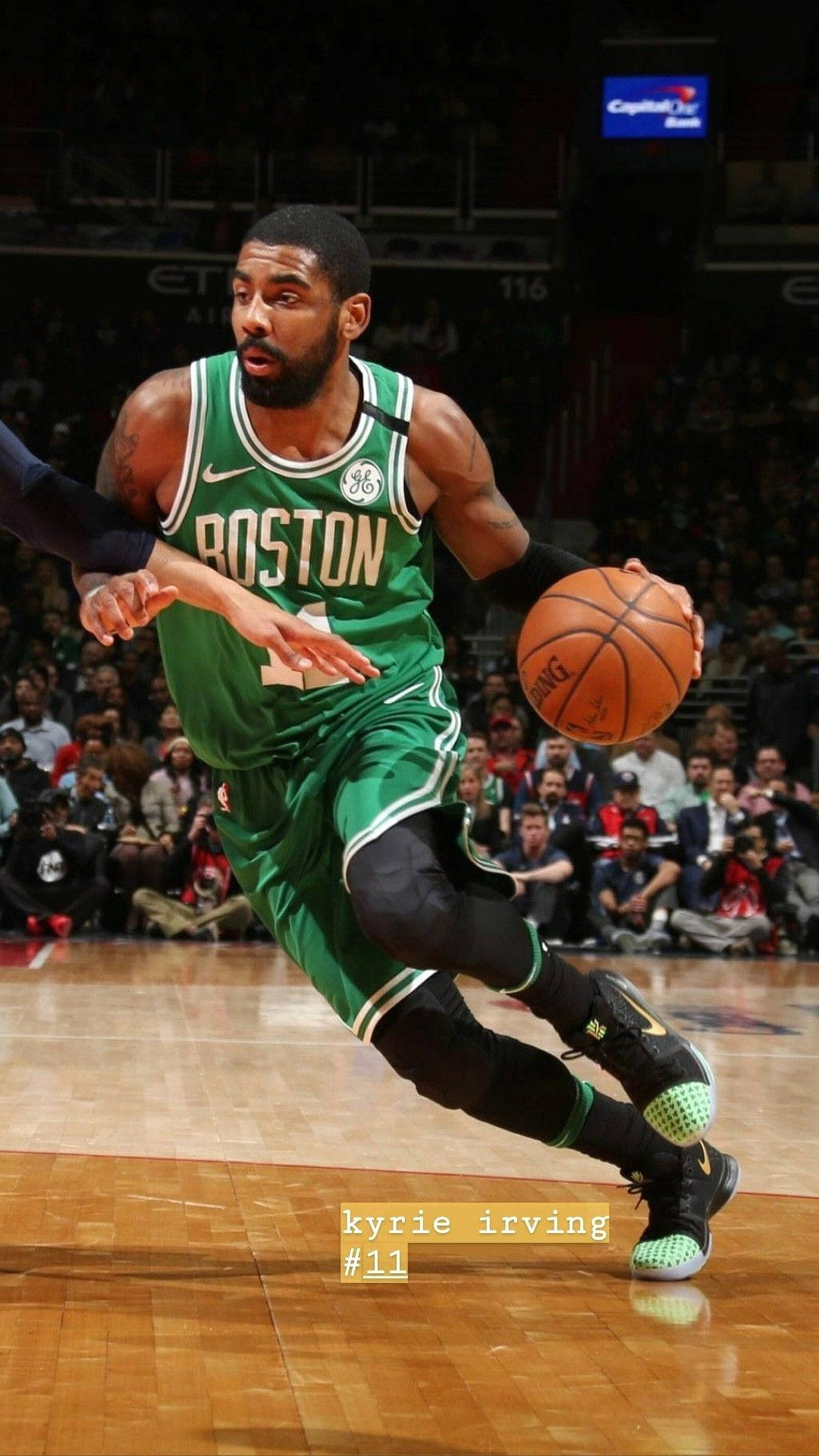 Kyrie 桌布 壁紙 — 凱里·厄文身穿綠色波士頓塞爾提克球衣，在場館燈光下激烈比賽中運球。