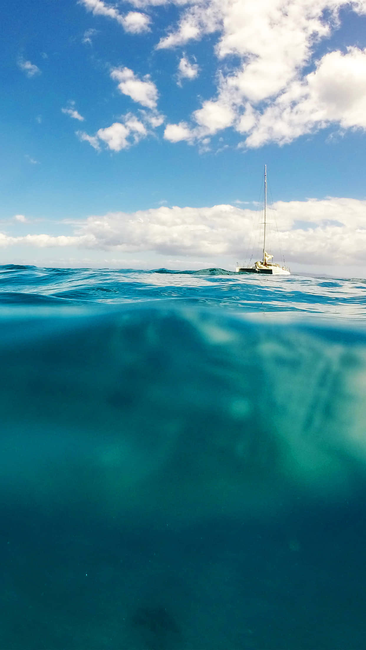 Boating 桌布 壁紙 — 分層視圖顯示一艘帆船漂浮在碧綠的海浪上，上方是明亮的藍天和蓬鬆的白雲。