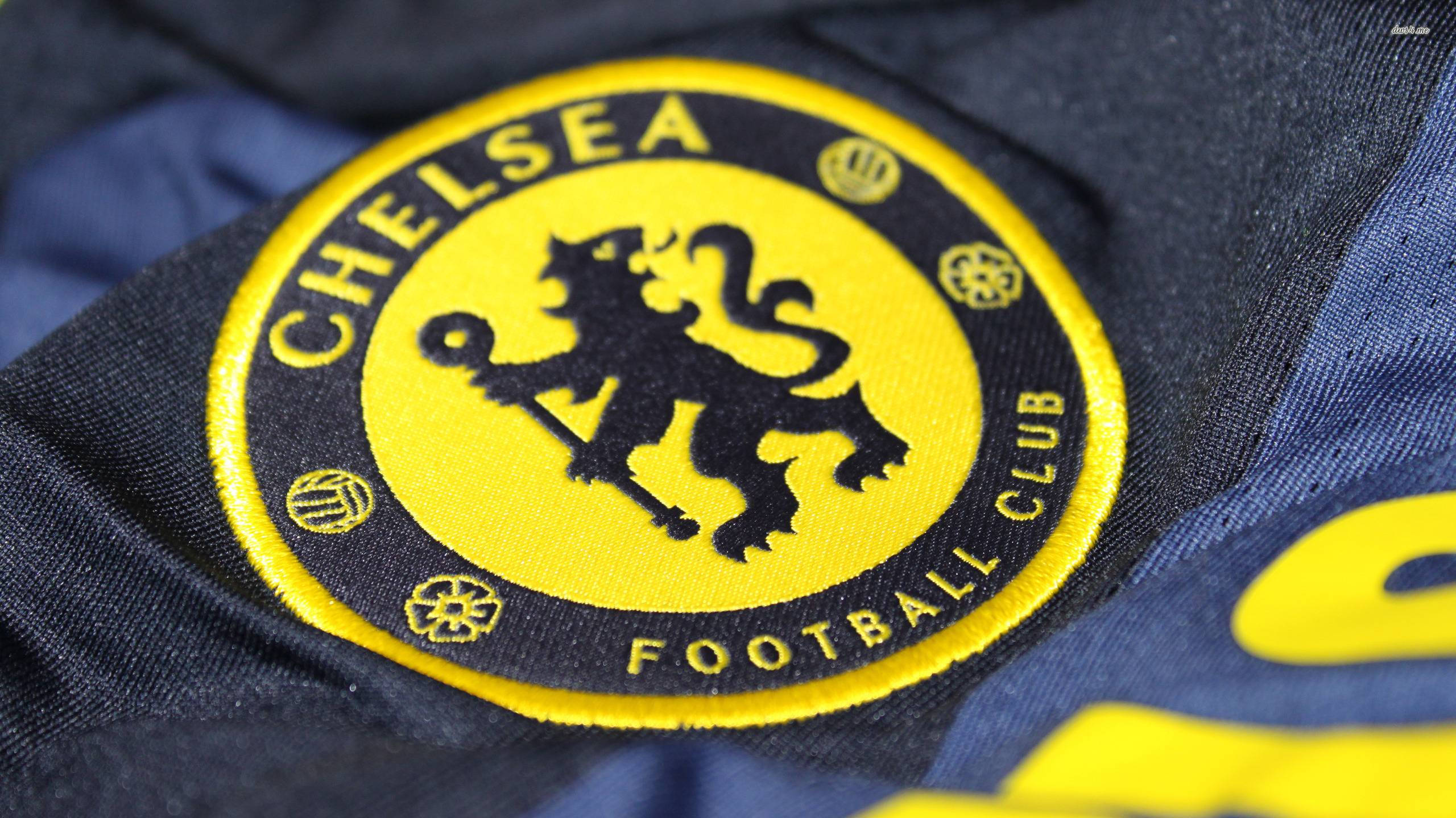 chelsea fc logo 桌布 壁紙 — 切爾西足球俱樂部刺繡會徽近距離特寫，位於海軍藍色球衣上，配以黃色點綴。