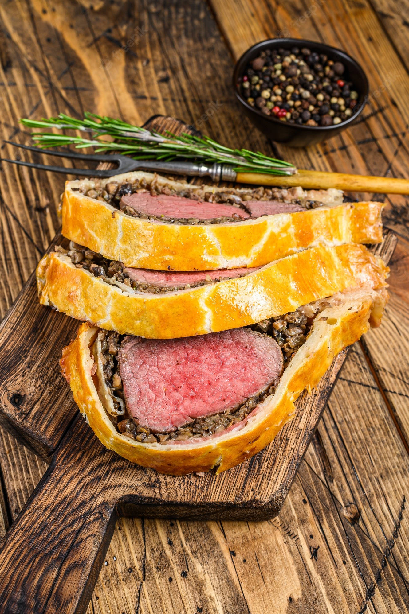meat 桌布 壁紙 — 切片威靈頓牛排配金黃酥皮和迷迭香，放在質樸木板上。