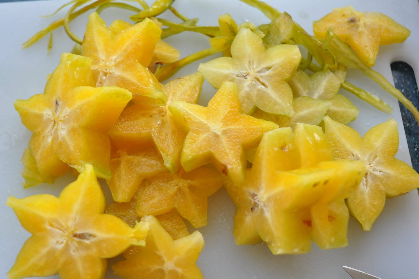 Fruit 桌布 壁紙 — 切片楊桃在白色砧板上排列成星形圖案，旁邊有刀。