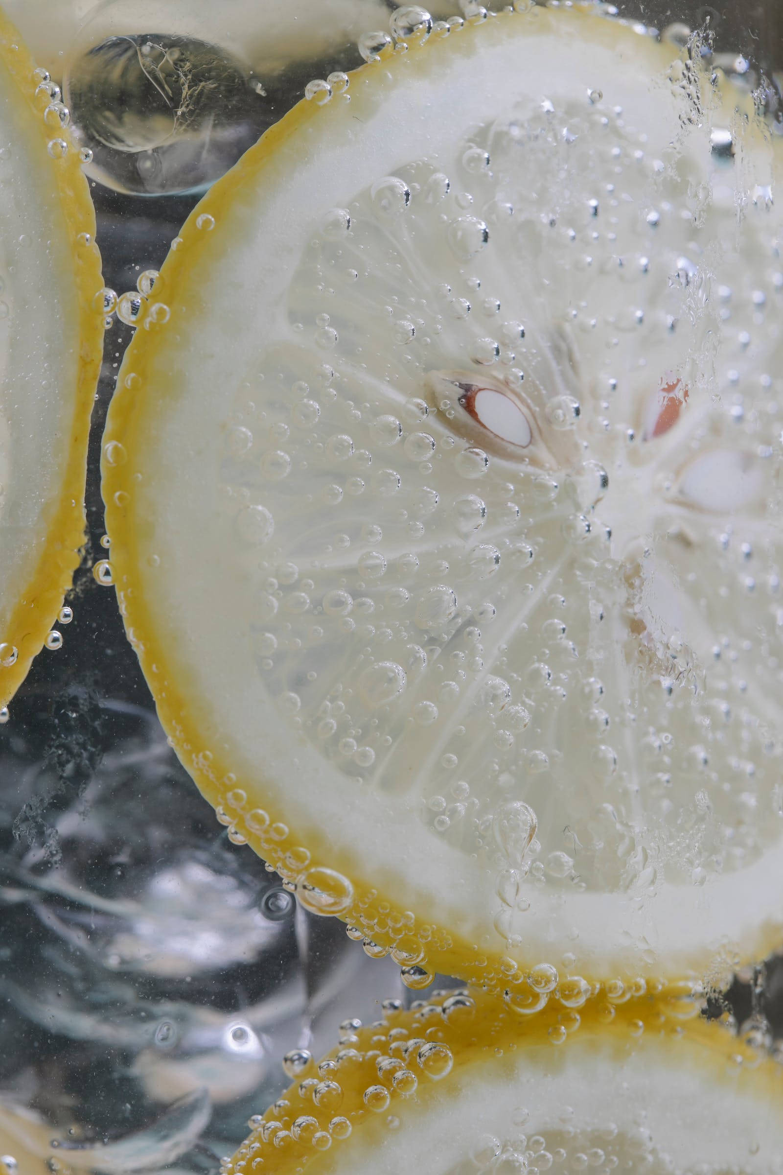 Cool Water 桌布 壁紙 — 切片檸檬漂浮在氣泡水中，氣泡附著在多汁的果肉上。