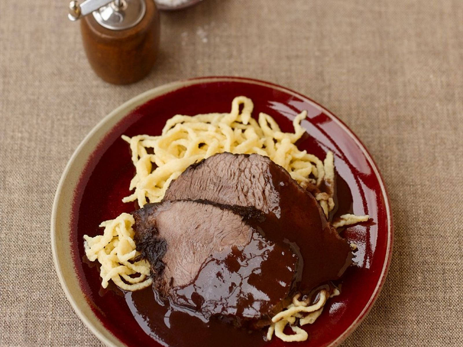 meat 桌布 壁紙 — 切片烤牛肉塗上濃郁深色醬汁，放在深紅色盤子上的金色麵疙瘩上。
