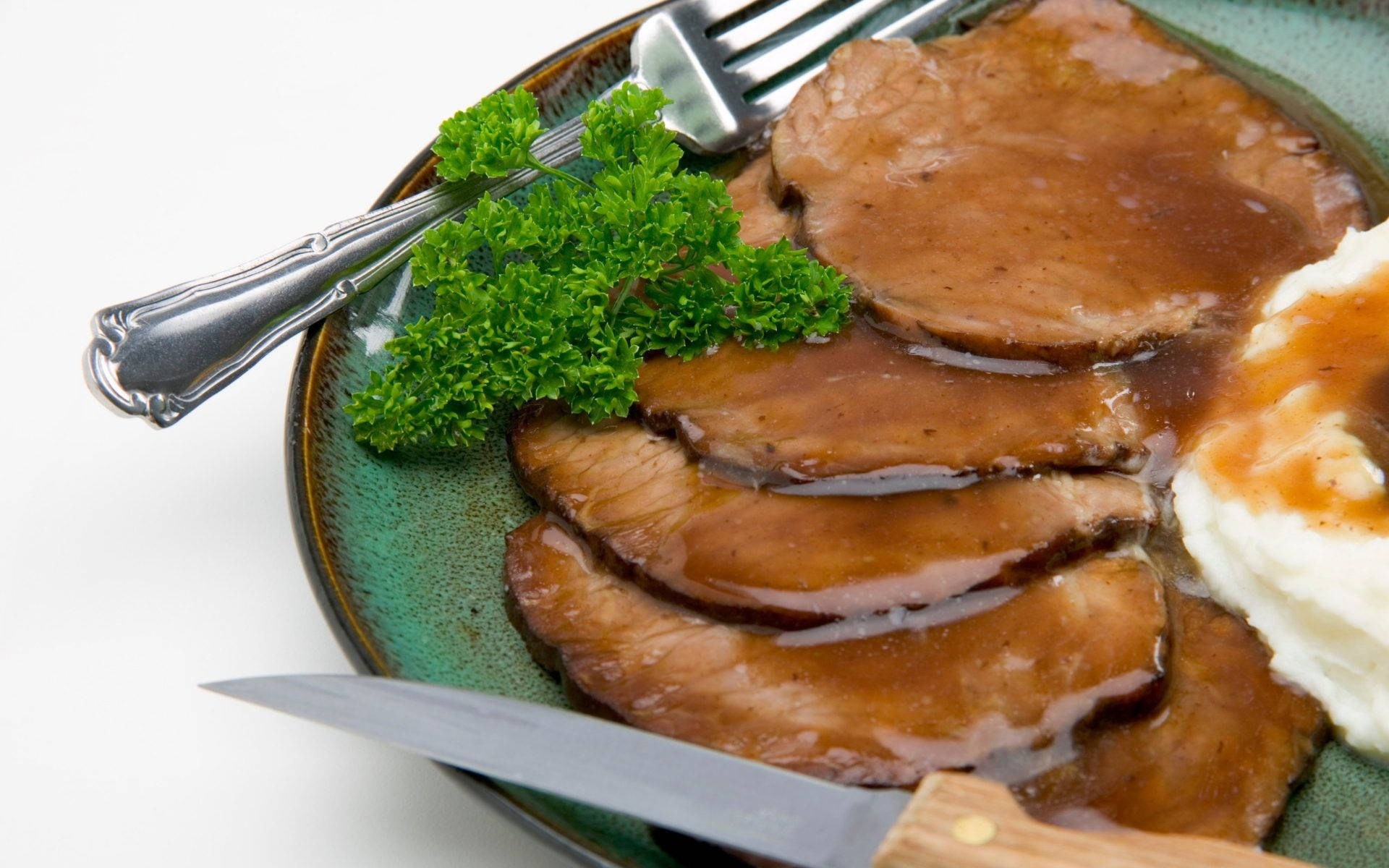 meat 桌布 壁紙 — 切片烤牛肉配肉汁和馬鈴薯泥，以歐芹裝飾，放在綠色盤子上，附有餐具。