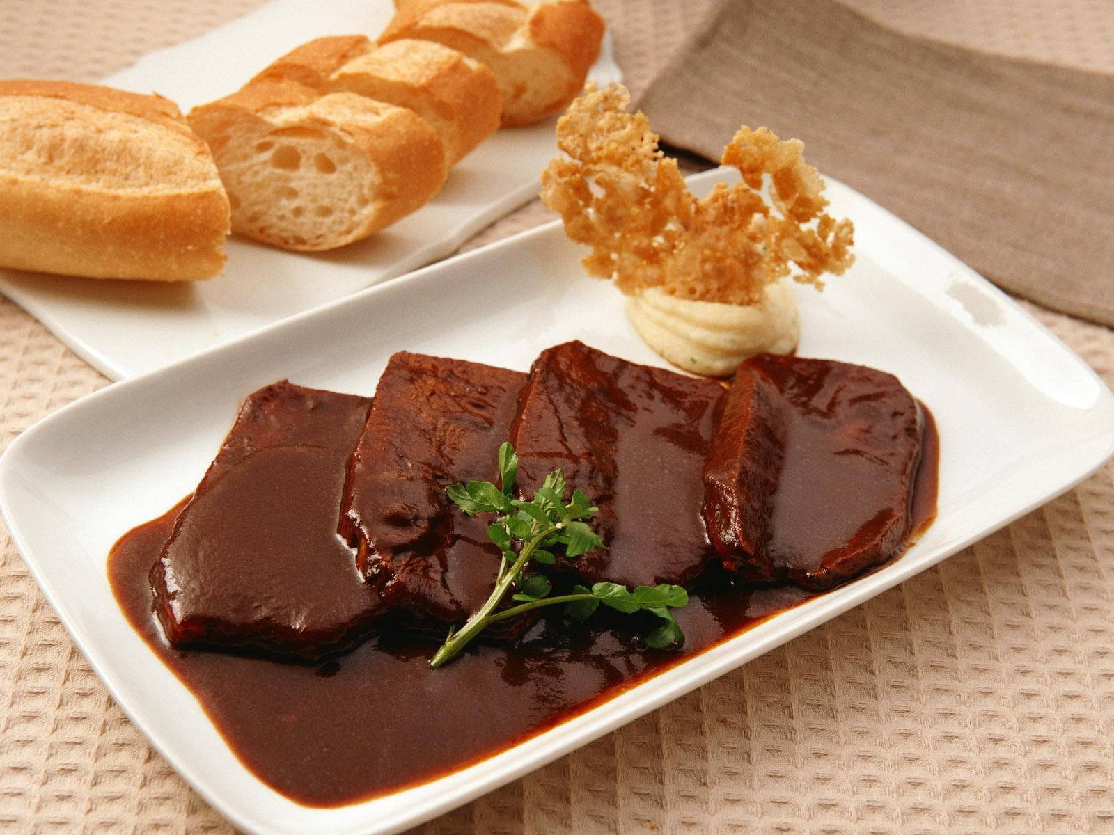 meat 桌布 壁紙 — 切片肝臟配濃郁深色醬汁，飾以歐芹和脆蔥，放在白色盤子上，附法式長棍麵包。