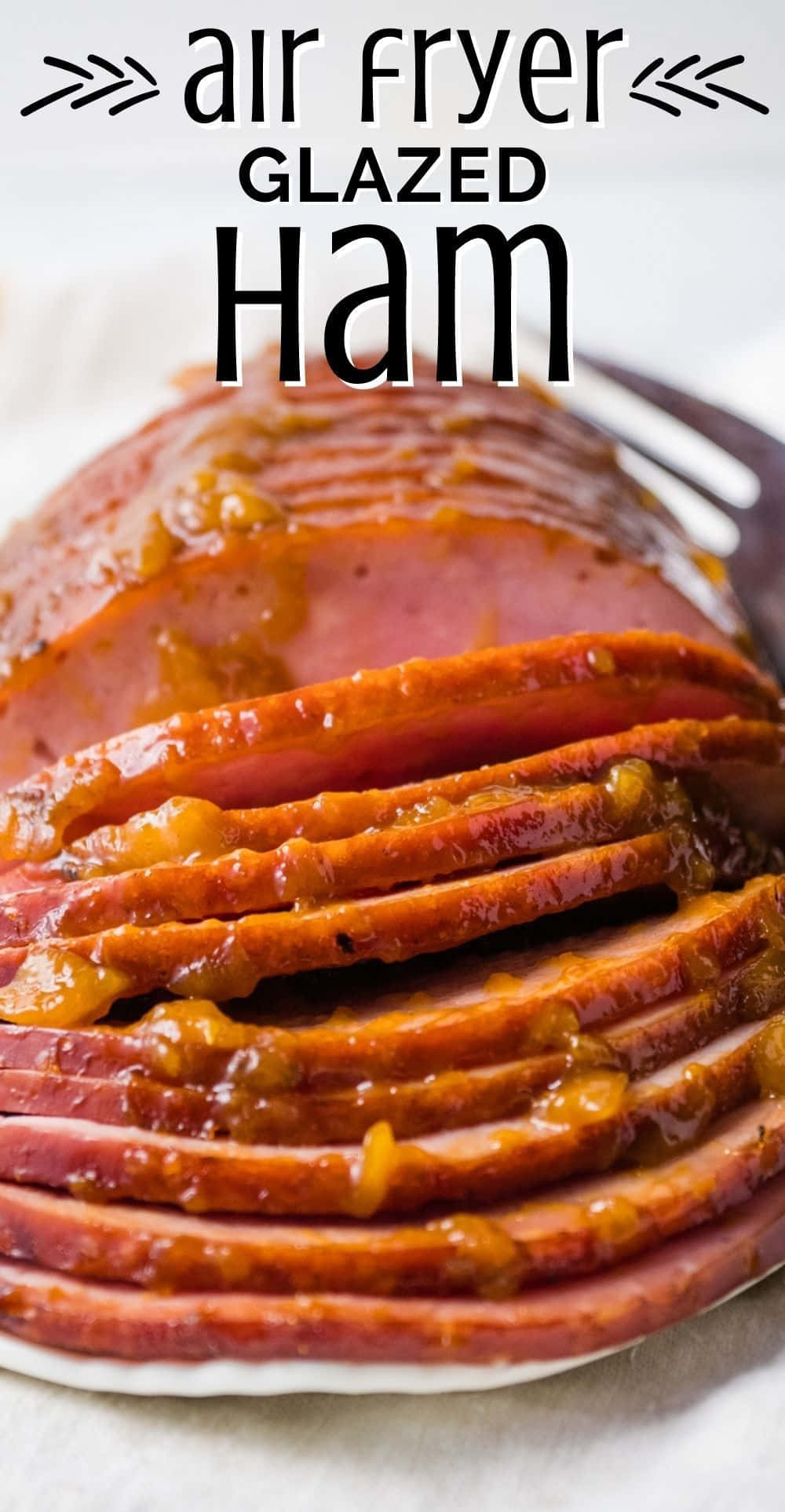 Black Forest Ham 桌布 壁紙 — 切片蜜汁火腿，帶有焦糖橙釉，在白色盤子上閃閃發光，旁邊放著叉子。