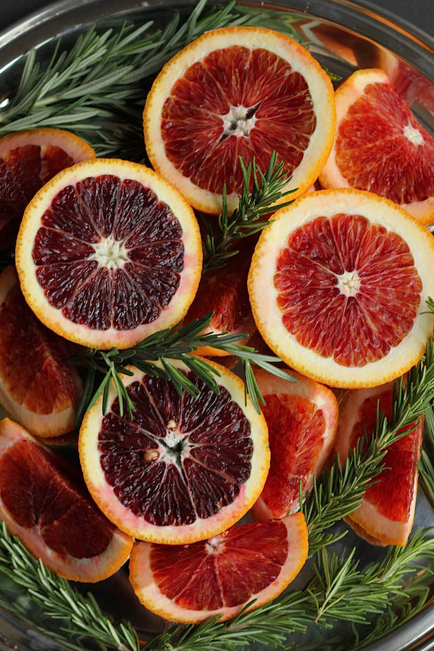 Fruit 桌布 壁紙 — 切片血橙，深紅果肉，搭配綠色迷迭香枝，擺放在金屬碗中。