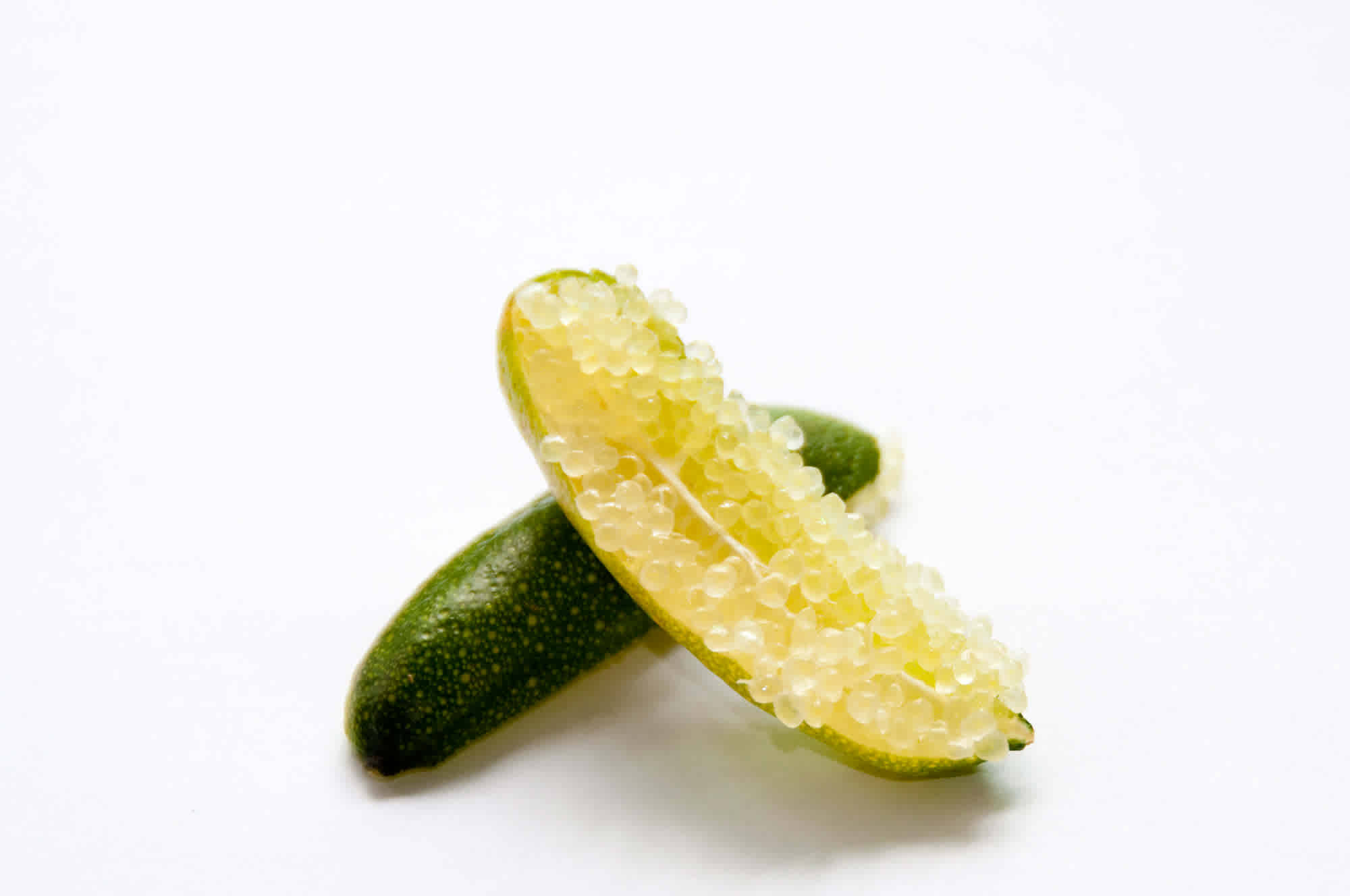 Fruits 桌布 壁紙 — 切片金桔露出閃閃發光的半透明種子，背景為純白色。