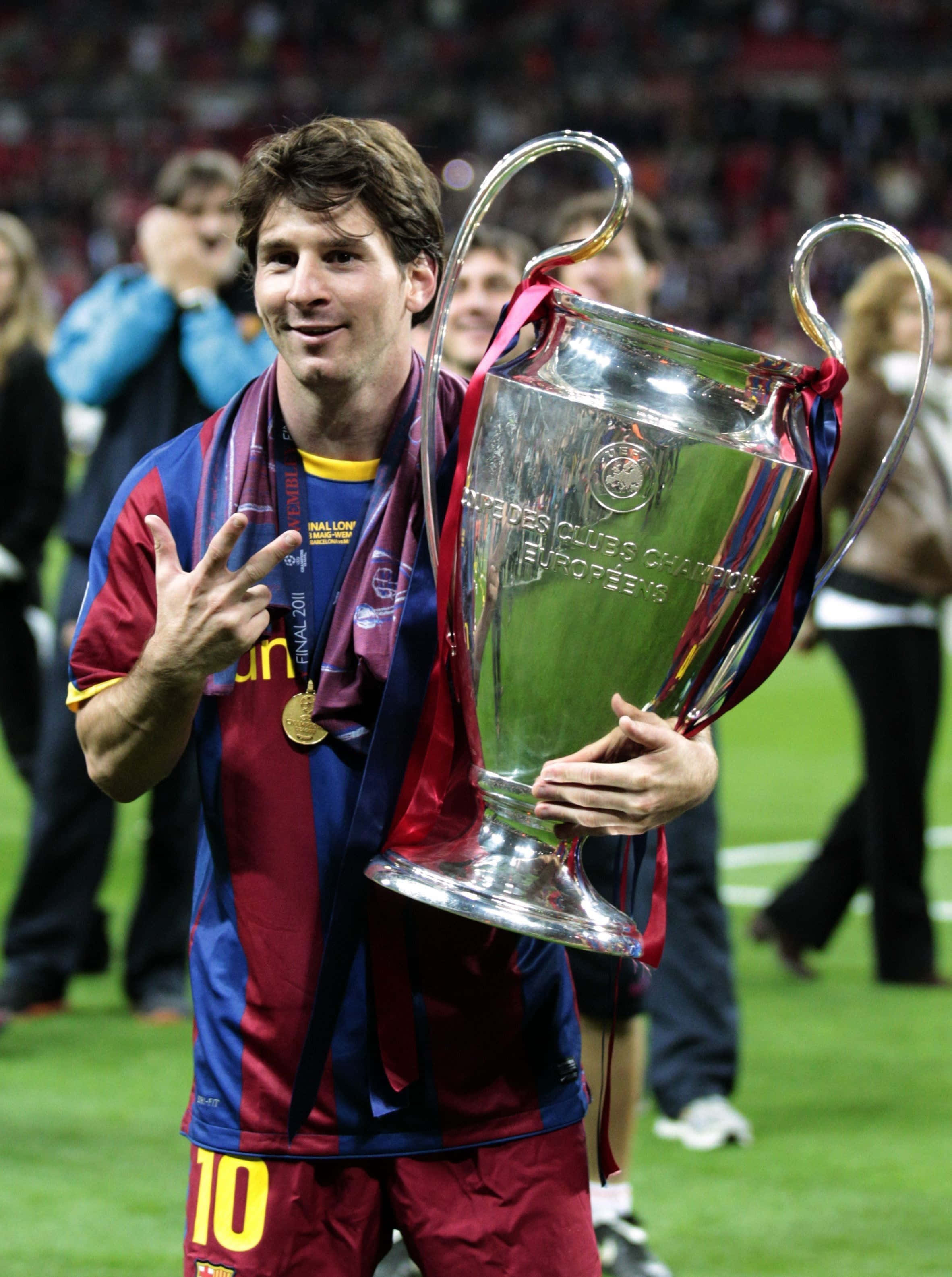 Champions League 桌布 壁紙 — 利昂內爾·梅西在勝利後於球場自豪地高舉歐冠獎盃微笑。