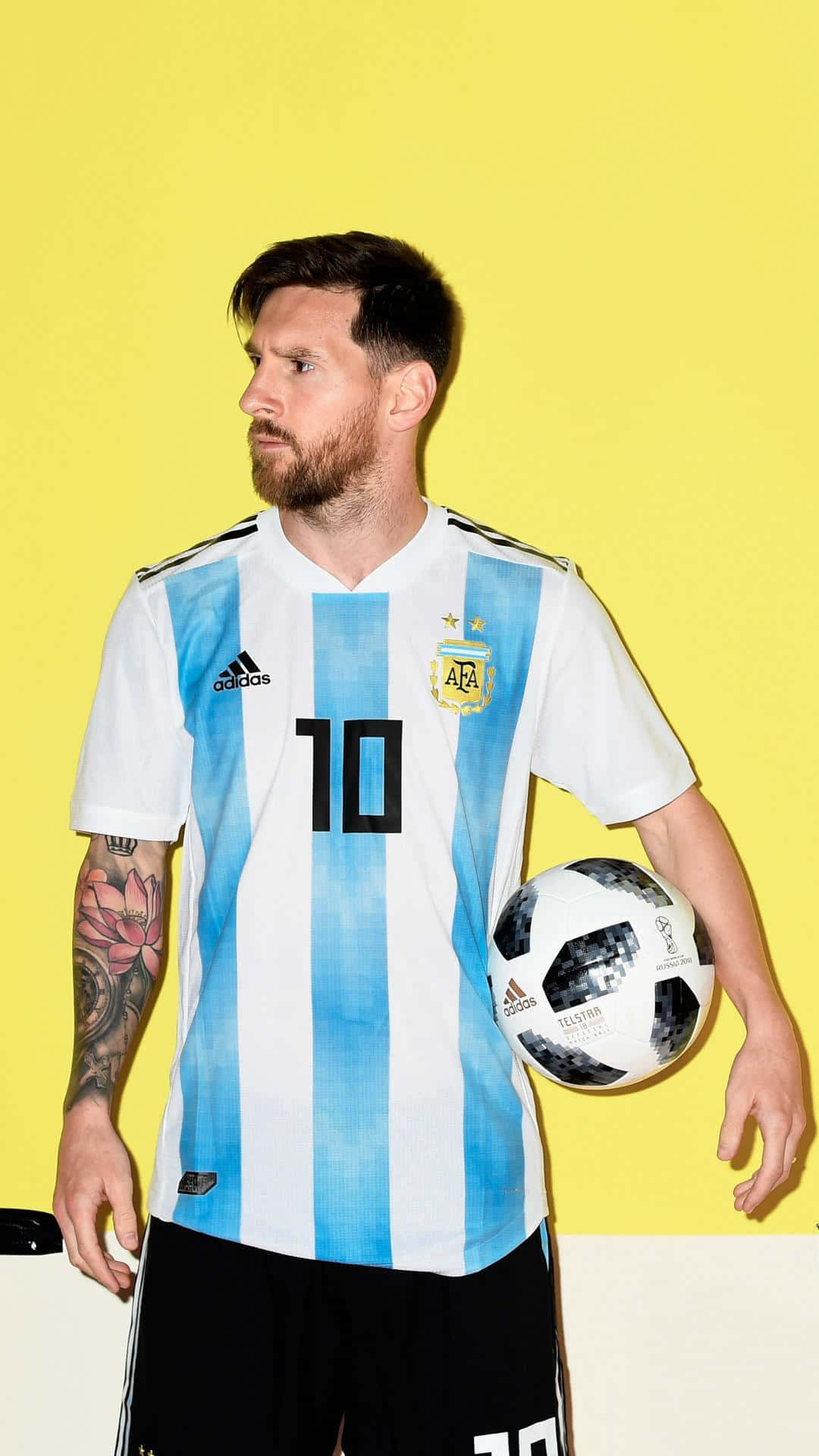 Argentina 桌布 壁紙 — 利昂內爾·梅西身穿阿根廷藍白條紋球衣，在明亮的黃色背景前手持足球。