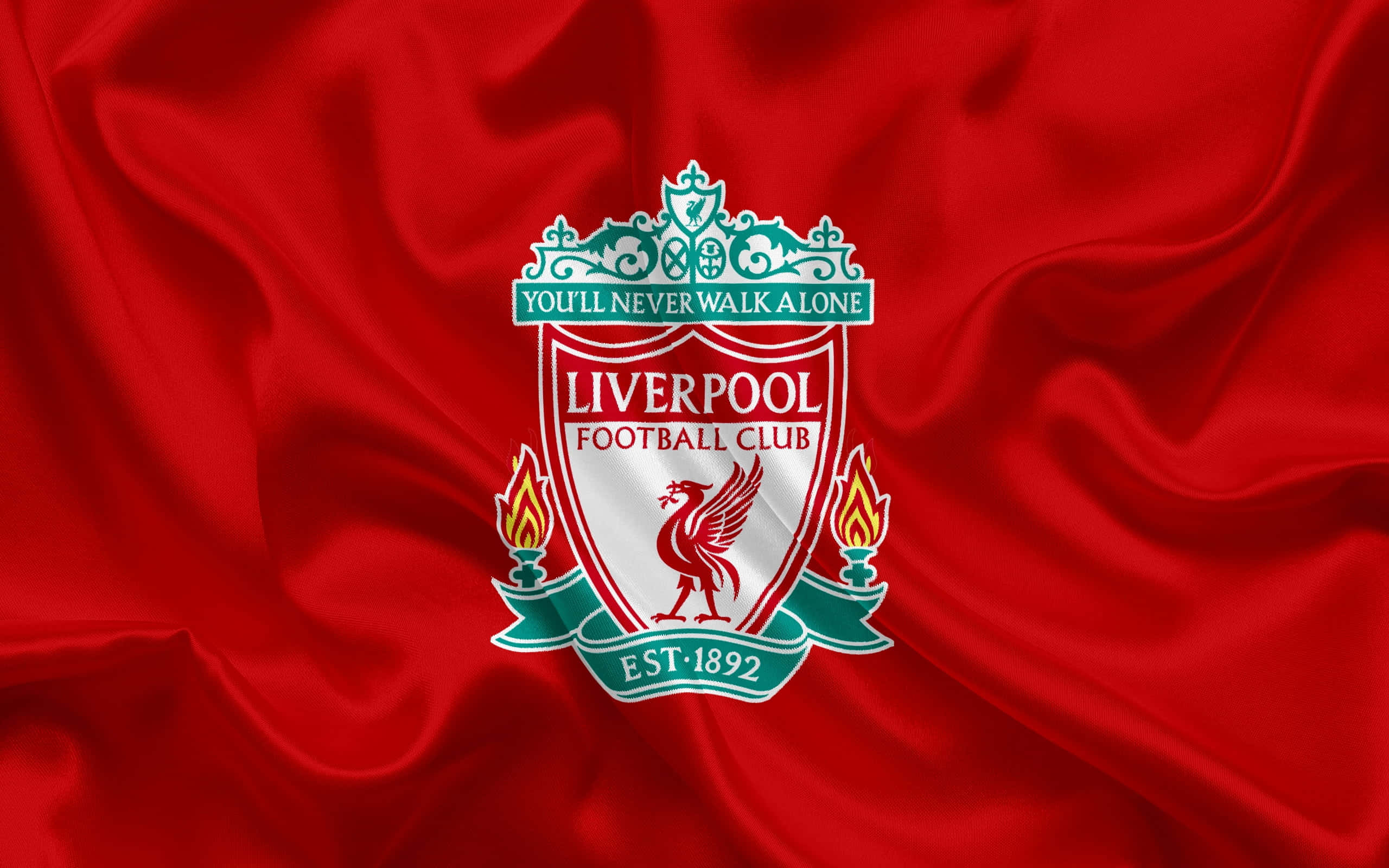 Liverpool Logo 桌布 壁紙 — 利物浦足球俱樂部徽章在豪華的紅色緞面布料上閃耀著鮮豔的紅色和綠色，帶有流暢的褶皺。