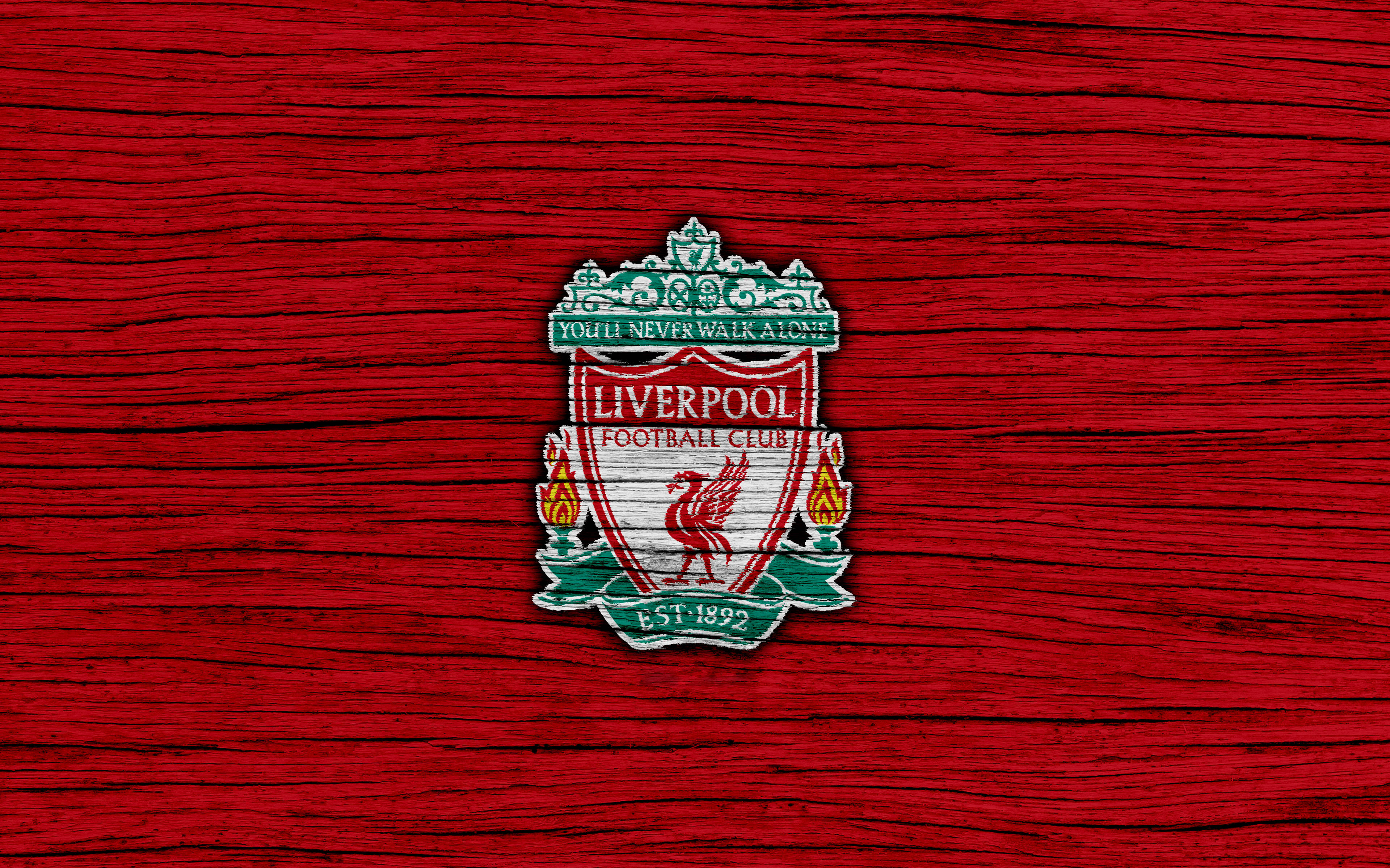 Liverpool Fc 桌布 壁紙 — 利物浦足球俱樂部徽章繡在帶有綠色和白色點綴的紋理紅色布料上。