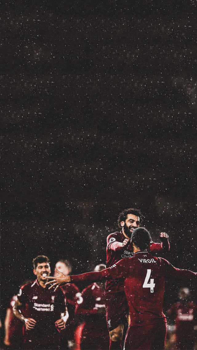 Liverpool iPhone 桌布 壁紙 — 利物浦足球員在雨中慶祝進球，面露喜悅，身穿紅色球衣。