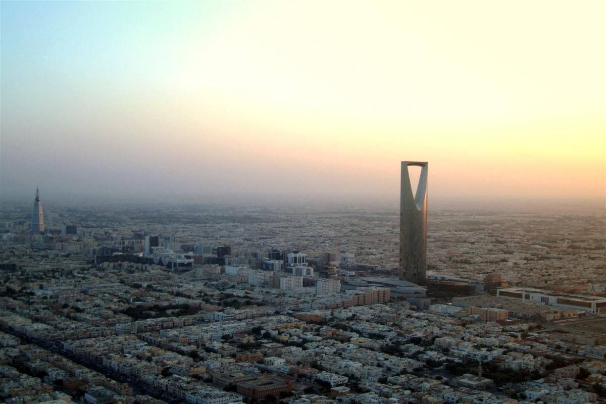 Riyadh 桌布 壁紙 — 利雅得天際線的鳥瞰圖，日落時分，王國塔和阿爾費薩利亞塔刺穿朦朧的橙色天空。