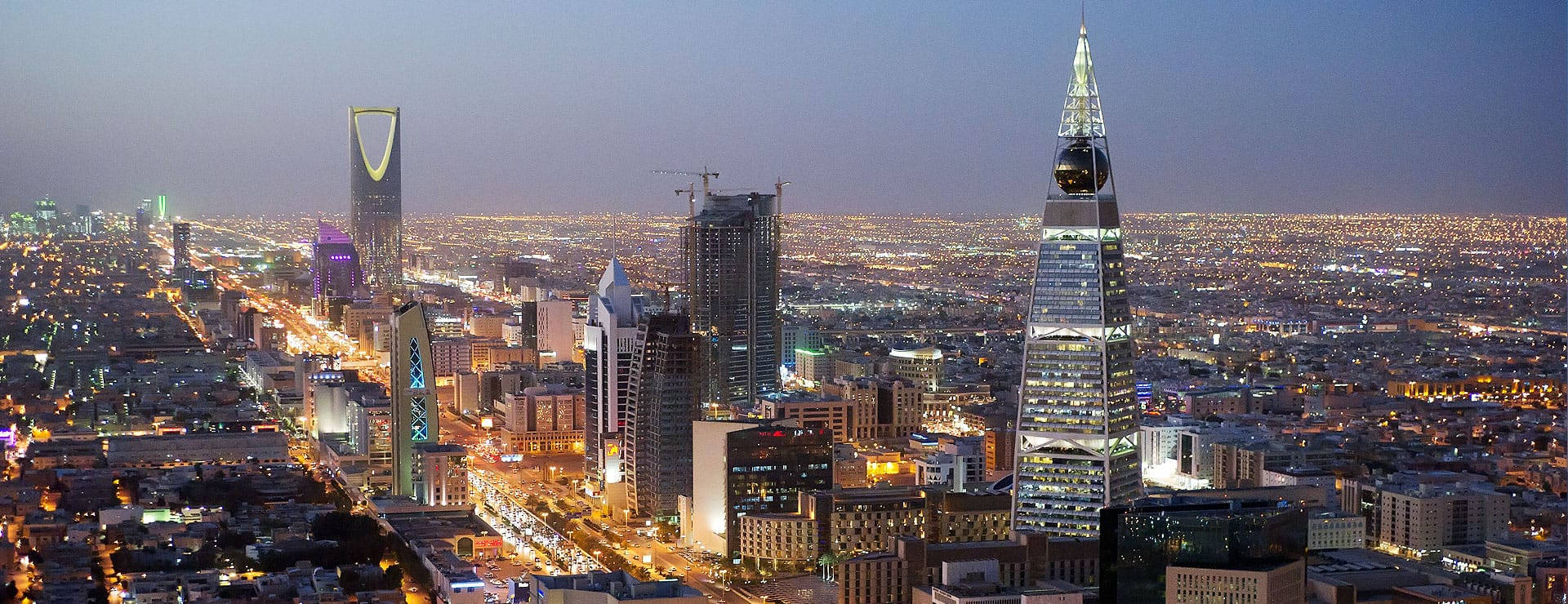 Riyadh 桌布 壁紙 — 利雅德城市景觀的鳥瞰圖，黃昏時分，摩天大樓和街道燈火通明。