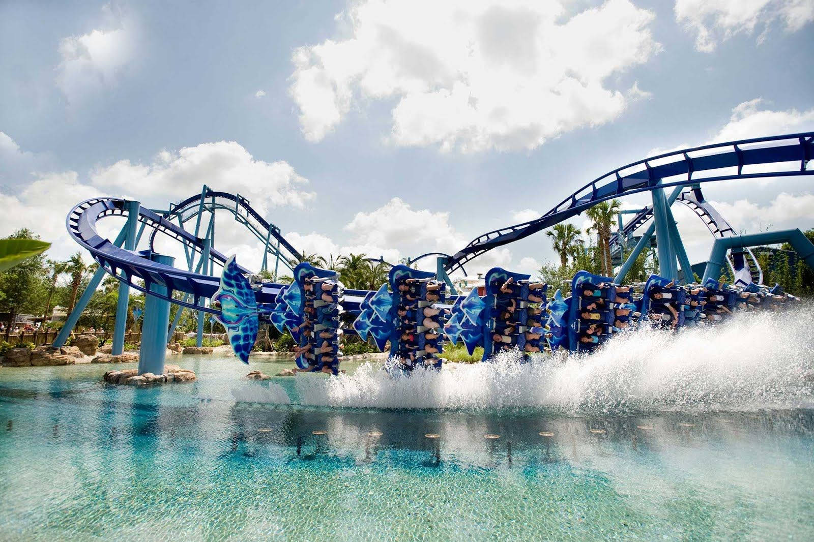 Roller Coaster 桌布 壁紙 — 刺激的藍色水上雲霄飛車將乘客發射到碧綠色的水面上，在明亮的陰天下產生爆炸性的水花。