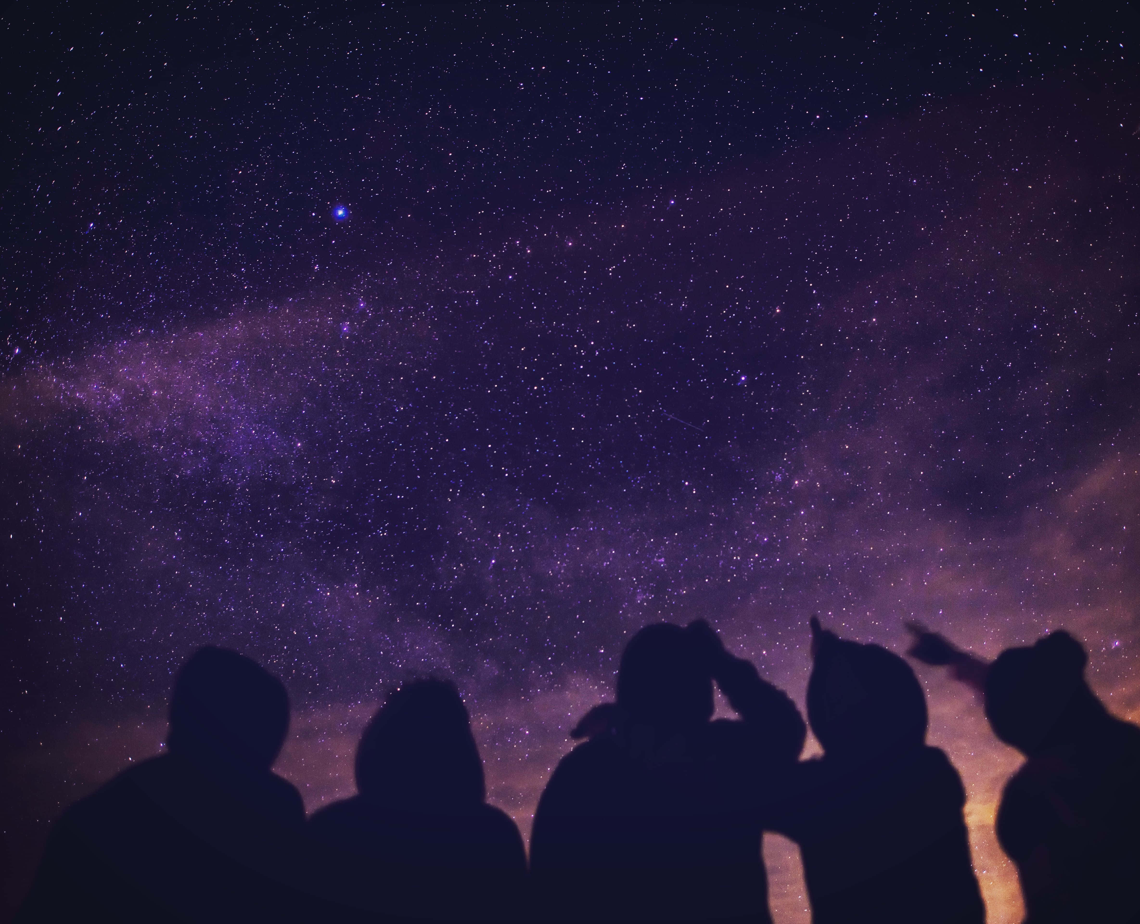 Silhouette 桌布 壁紙 — 剪影人物仰望充滿銀河系的鮮豔紫色和藍色星空，充滿驚奇。
