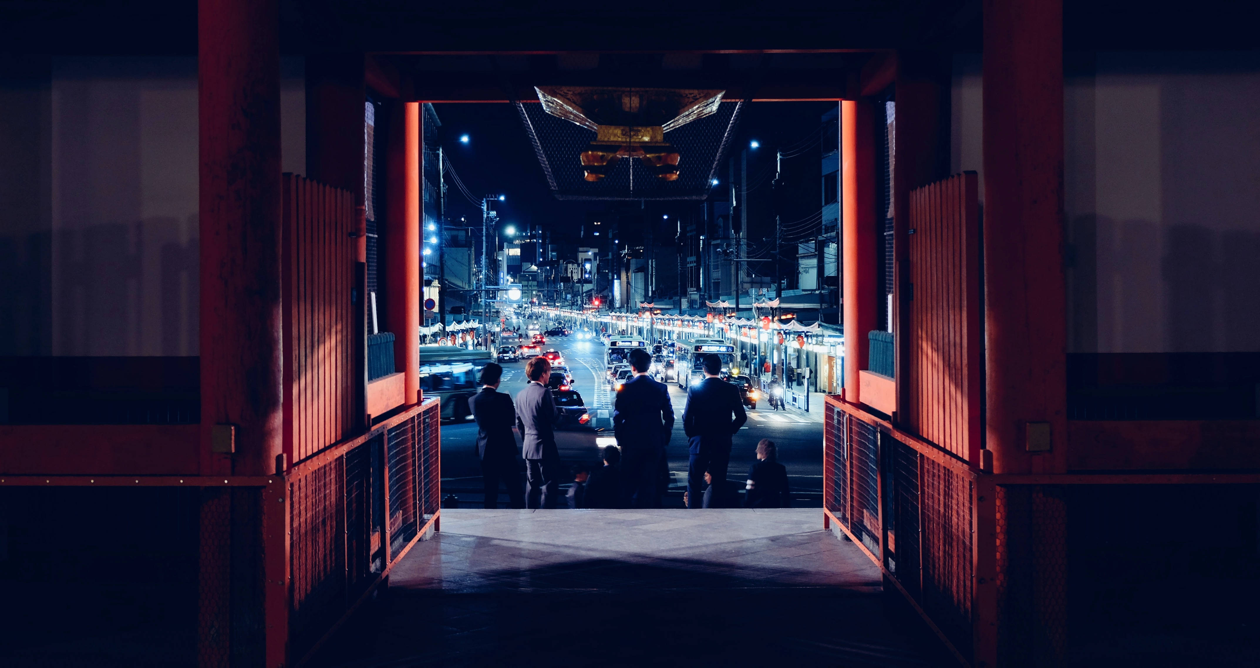 blade 桌布 壁紙 — 剪影人物站在發光的紅色鳥居下，框住夜晚繁忙的霓虹燈東京街道。
