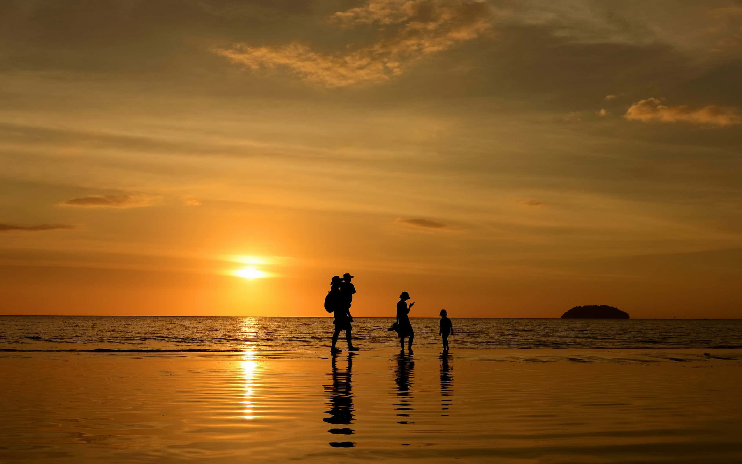 Family 桌布 壁紙 — 剪影家庭沿著濕漉漉的海灘行走，夕陽如火橙色，在水面上投下長長的倒影。