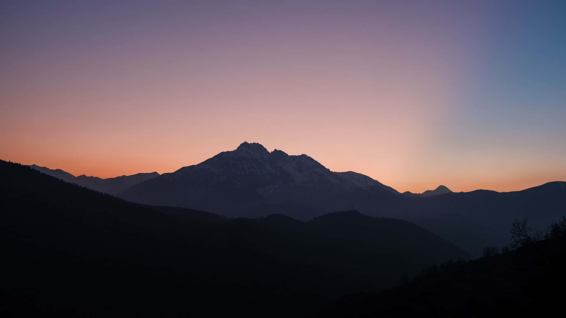 山景 桌布 壁紙 — 剪影山峰在漸變暮色天空中升起，散發柔和紫色和橙色色調。