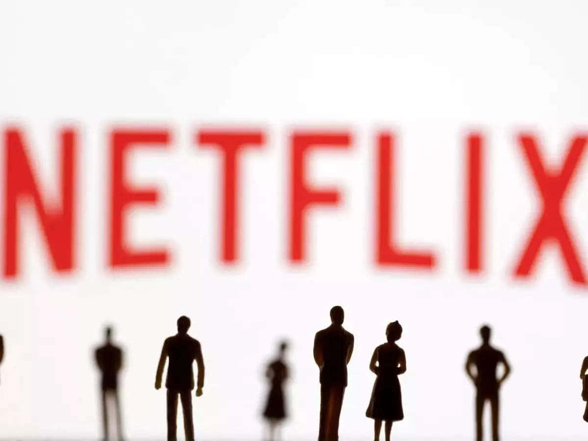 Netflix 桌布 壁紙 — 剪影微型人物站在明亮的白色背景前，面對模糊的紅色Netflix標誌。
