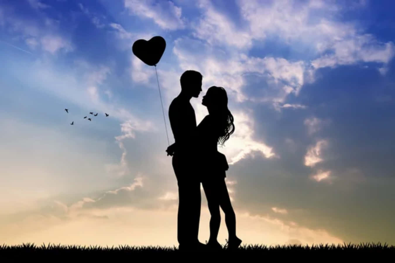 lover 桌布 壁紙 — 剪影情侶在充滿活力的日落天空下擁抱，手持心形氣球，附近有鳥兒飛翔。