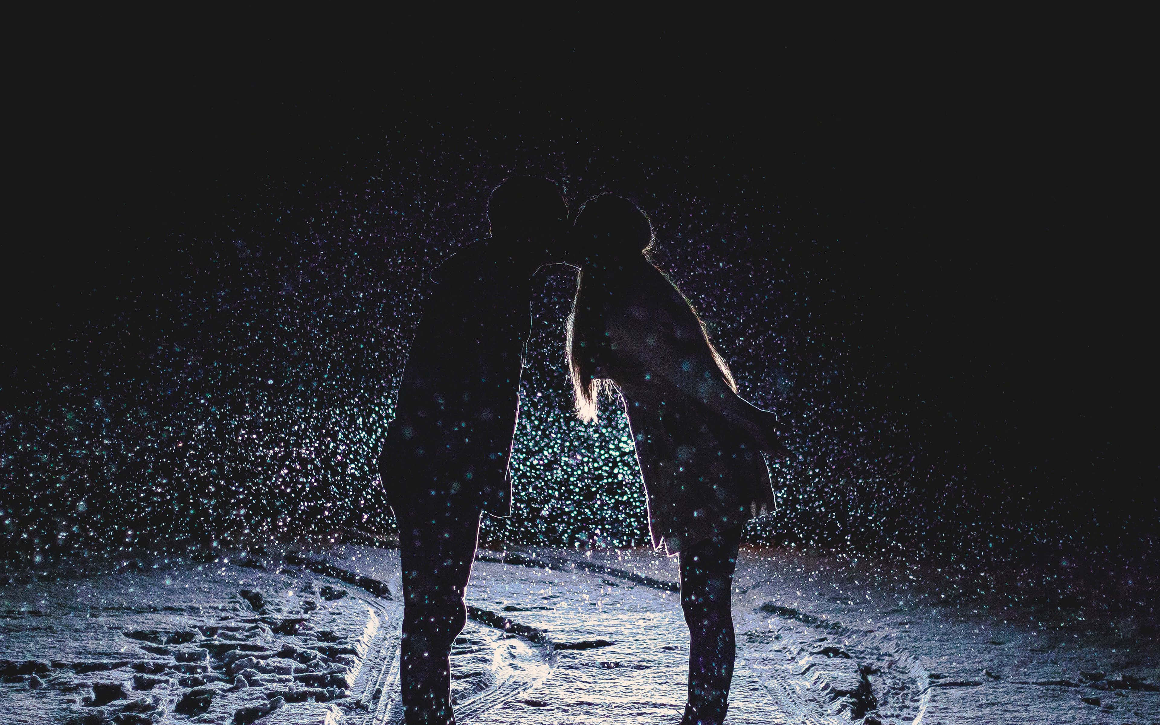 Dark Love 桌布 壁紙 — 剪影情侶在夜晚飄雪中親吻，周圍有發光粒子。