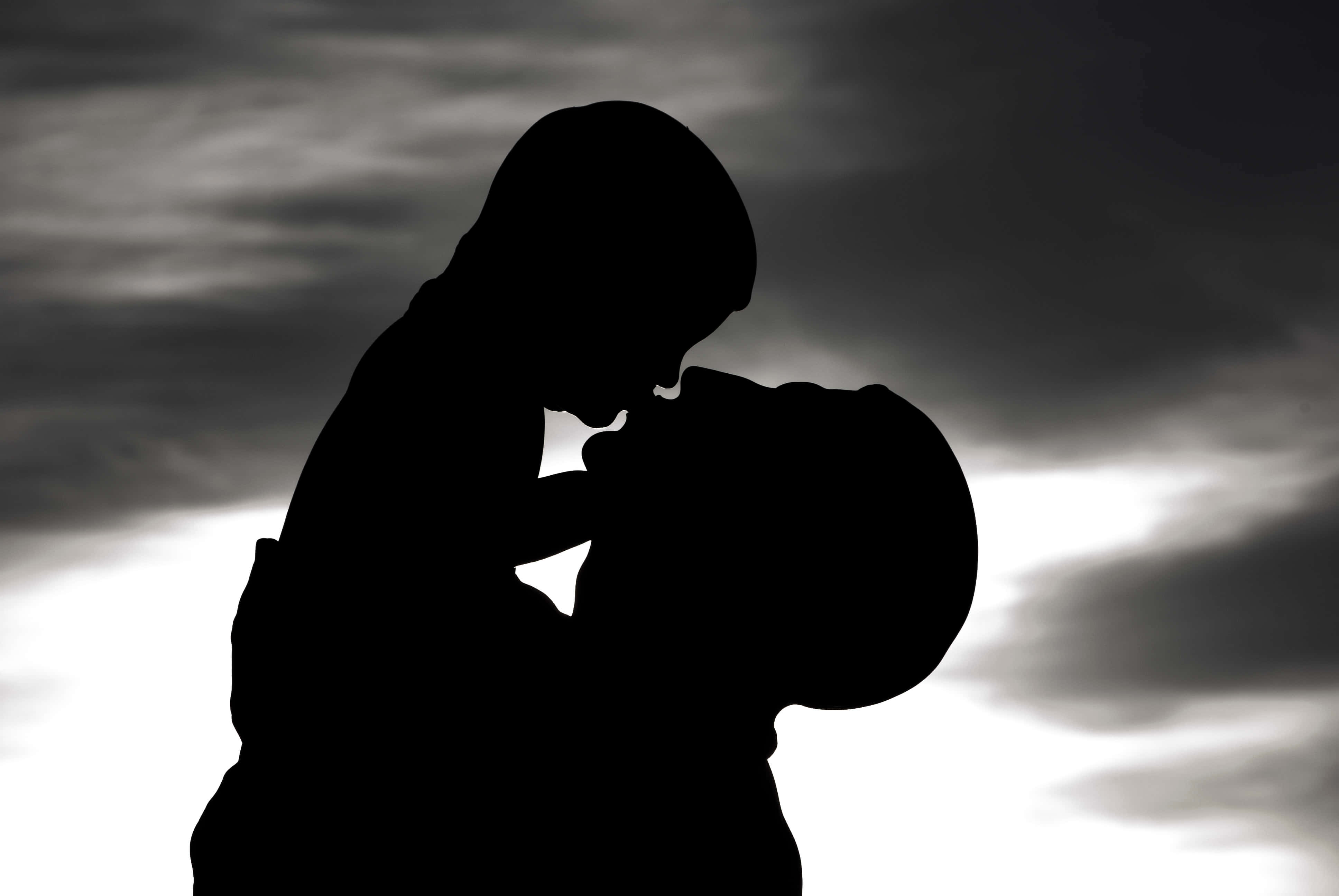 Father And Son 桌布 壁紙 — 剪影情侶在戲劇性的多雲天空下，背光中溫柔擁抱。