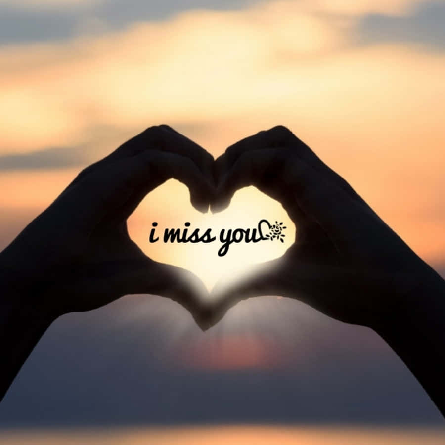 我想你 桌布 壁紙 — 剪影手形成心形，以「i miss you」文字框住太陽，背景是溫暖的日落天空。
