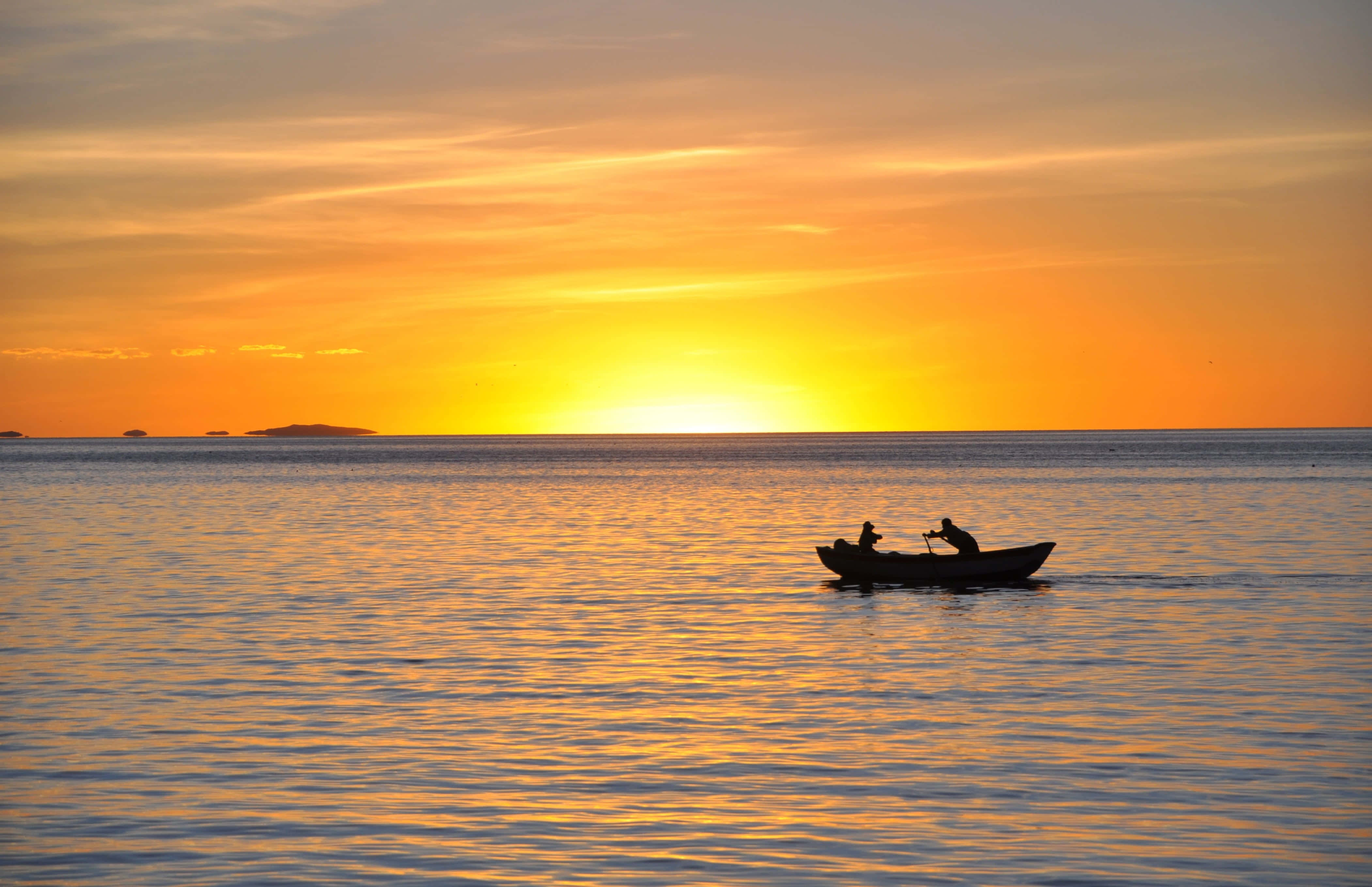 Boating 桌布 壁紙 — 剪影漁夫在小船上，於平靜的水面上漂流，夕陽以火熱的橙色和金色落下。