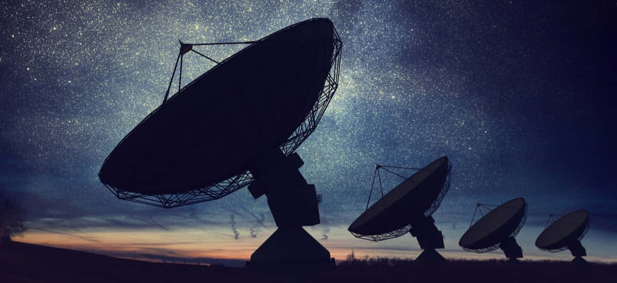 Satellite Technology 桌布 壁紙 — 剪影的電波望遠鏡矗立在星空暮色中，帶有橙色和深藍色的漸變色調。