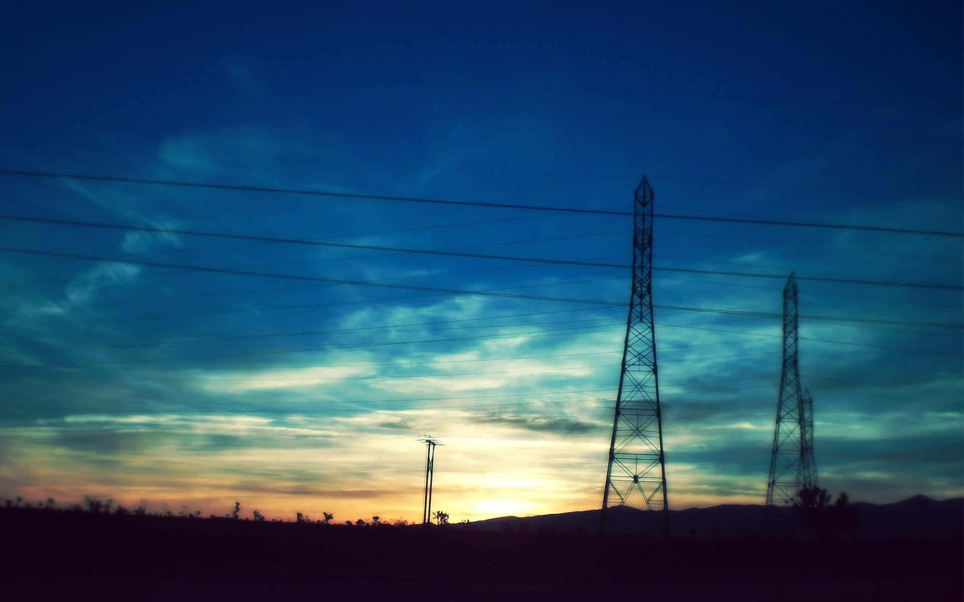 電力 桌布 壁紙 — 剪影的電線和電塔在充滿活力的暮色天空中延伸，帶有橙色和深藍色的條紋。
