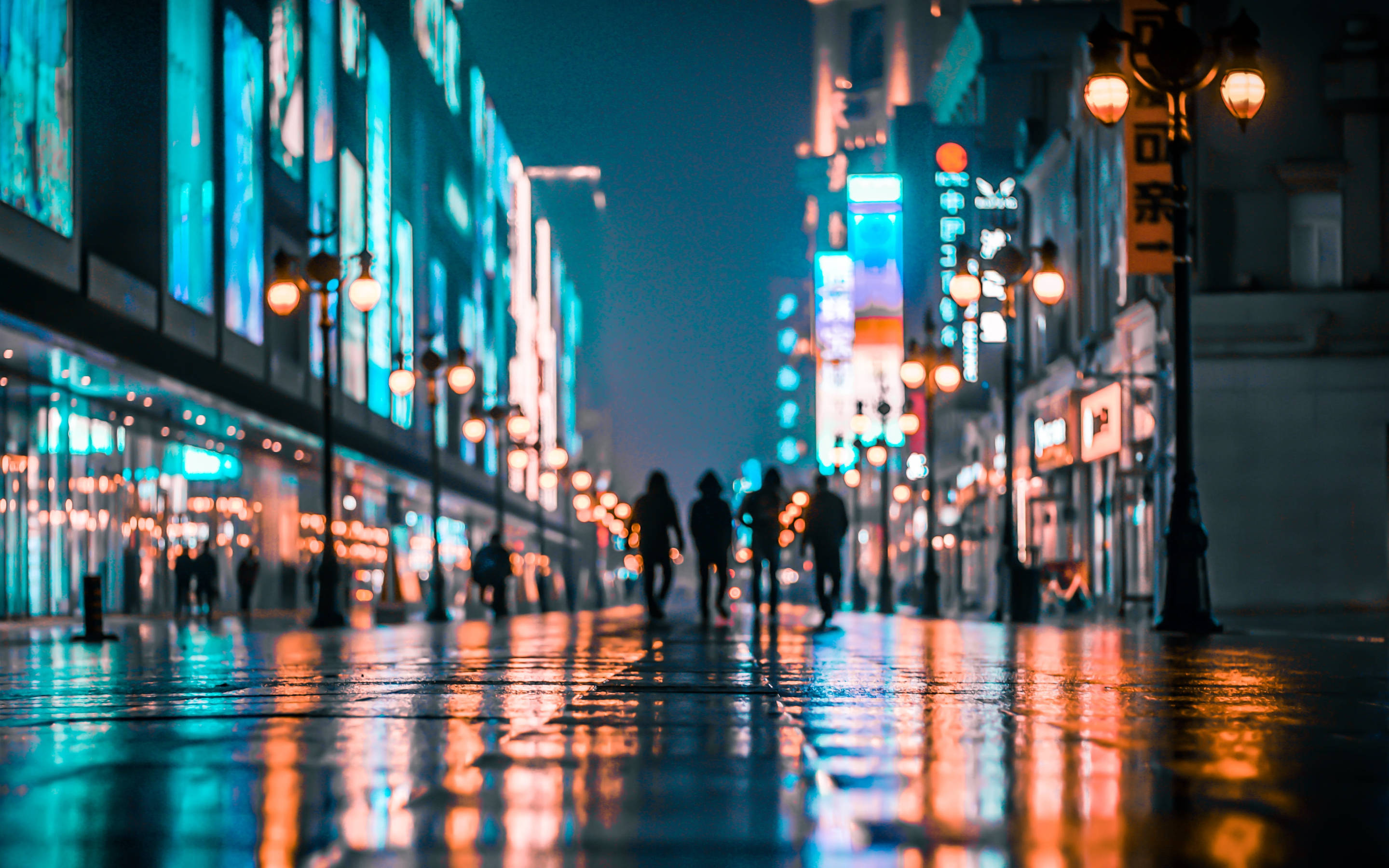 Tianjin 桌布 壁紙 — 剪影般的行人夜晚在雨水濕滑、霓虹燈照亮的城市街道上漫步，濕漉漉的人行道上反射著發光的倒影。