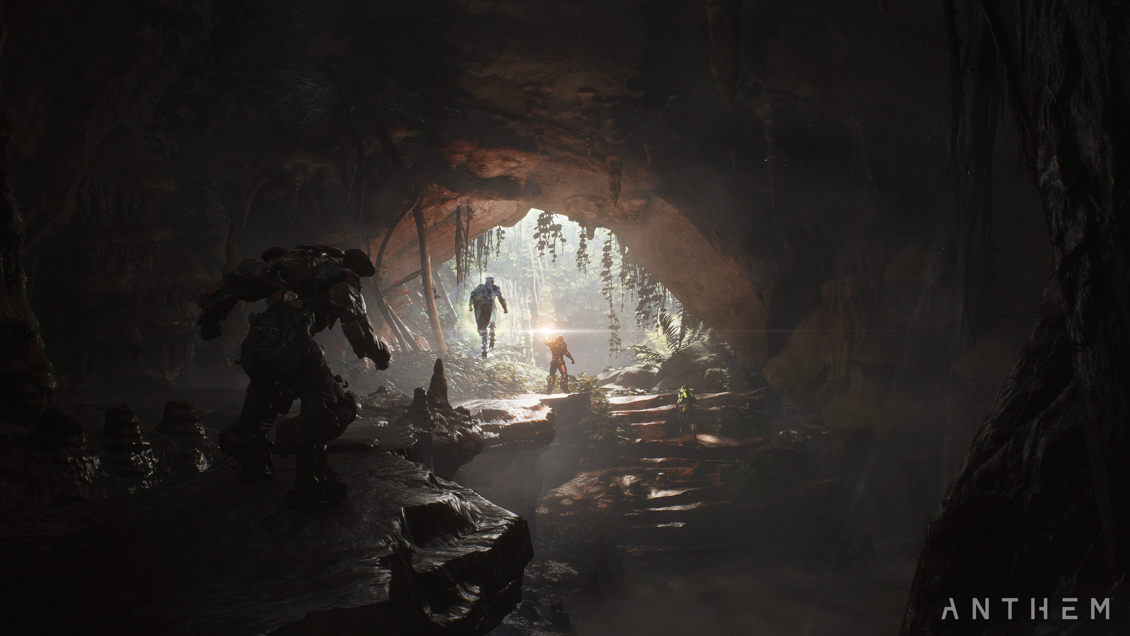 anthem 4K 桌布 壁紙 — 剪影般的裝甲人物從黑暗洞穴中出現，進入陽光明媚、有霧氣和懸掛藤蔓的叢林空地。