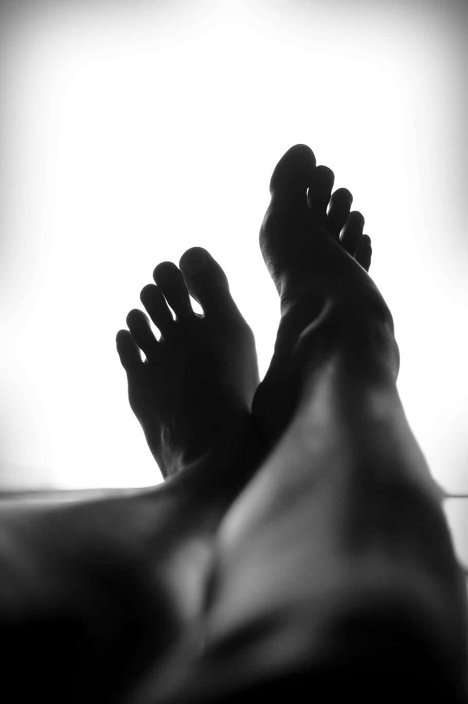 feet 桌布 壁紙 — 剪影般的赤腳在明亮的白色背景上放鬆休息，極簡黑白照片。