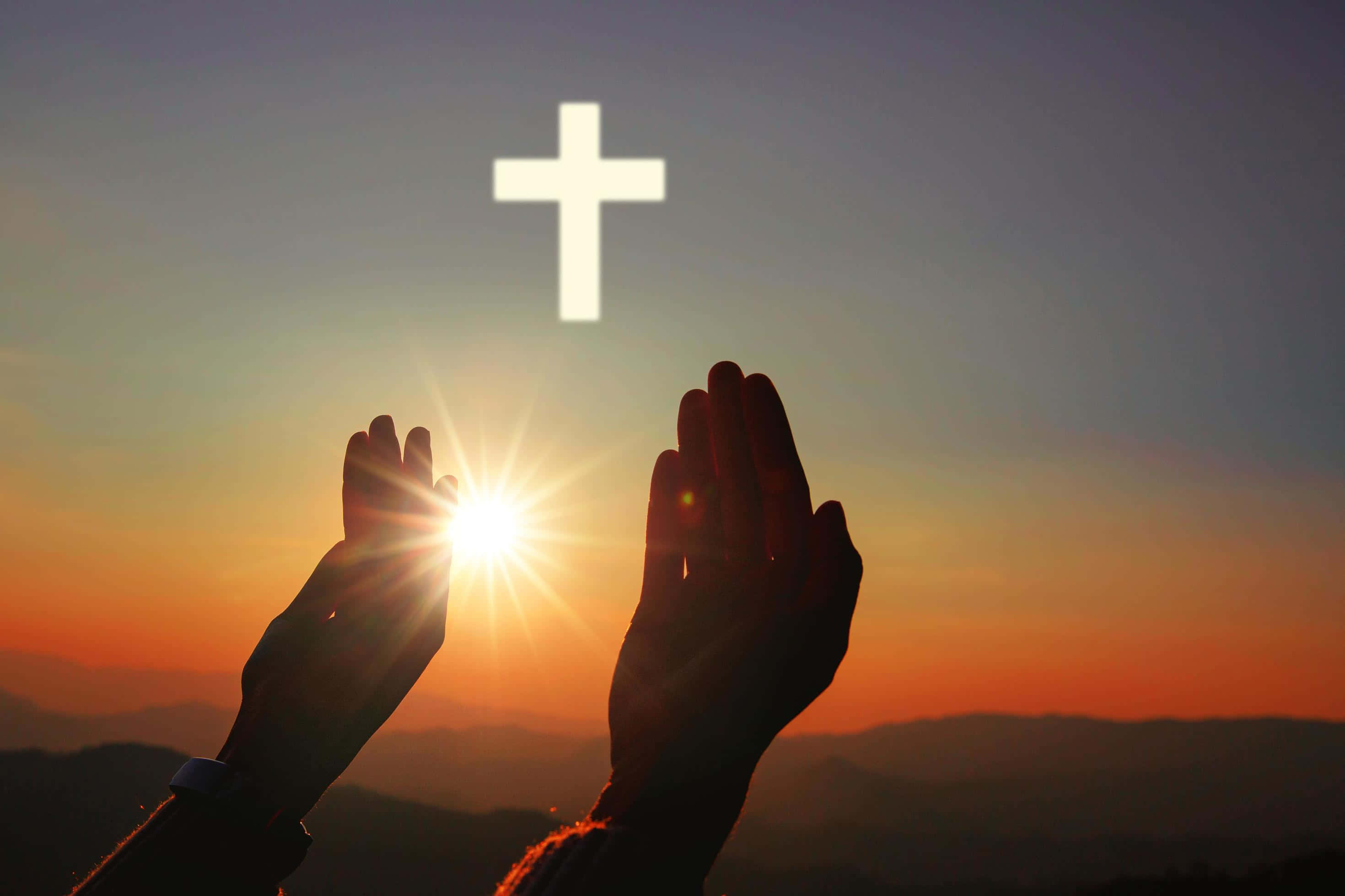 Prayer 桌布 壁紙 — 剪影雙手在發光的日落前祈禱，上方有光芒四射的十字架。