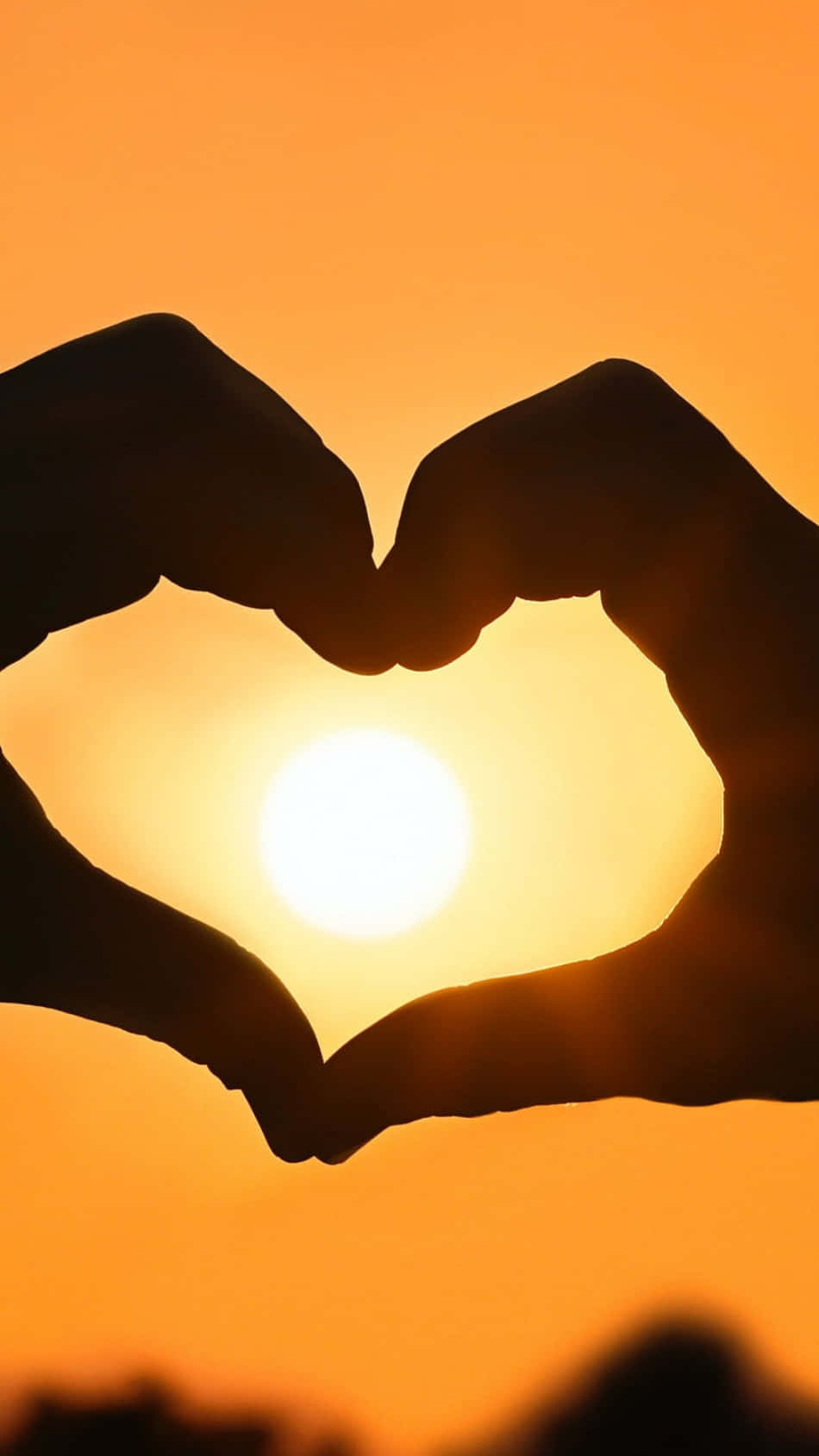 Heart Silhouette 桌布 壁紙 — 剪影雙手形成心形，框住溫暖橙色天空中的發光太陽。