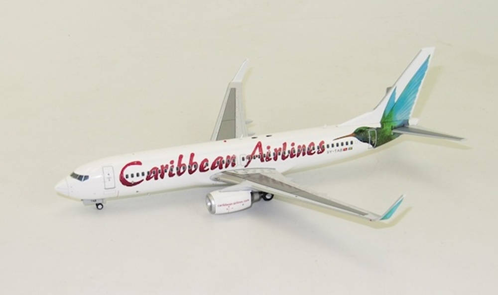  壁紙 — 加勒比航空波音737的詳細模型，帶有紅色字體和綠藍色尾翼，背景為純米白色。