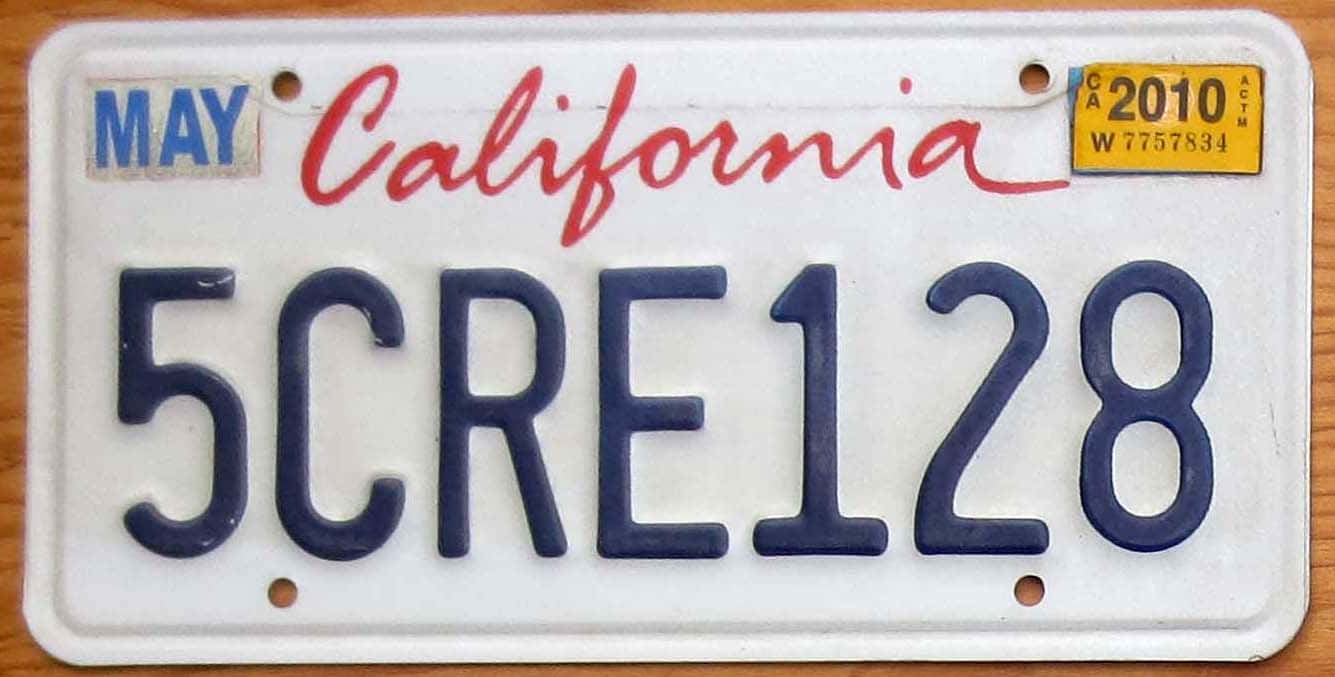 Car License Plate 桌布 壁紙 — 加州車牌的近距離特寫，帶有藍色字母和紅色字體，顯示「California」和號碼「5CRE128」，日期為2010年5月。