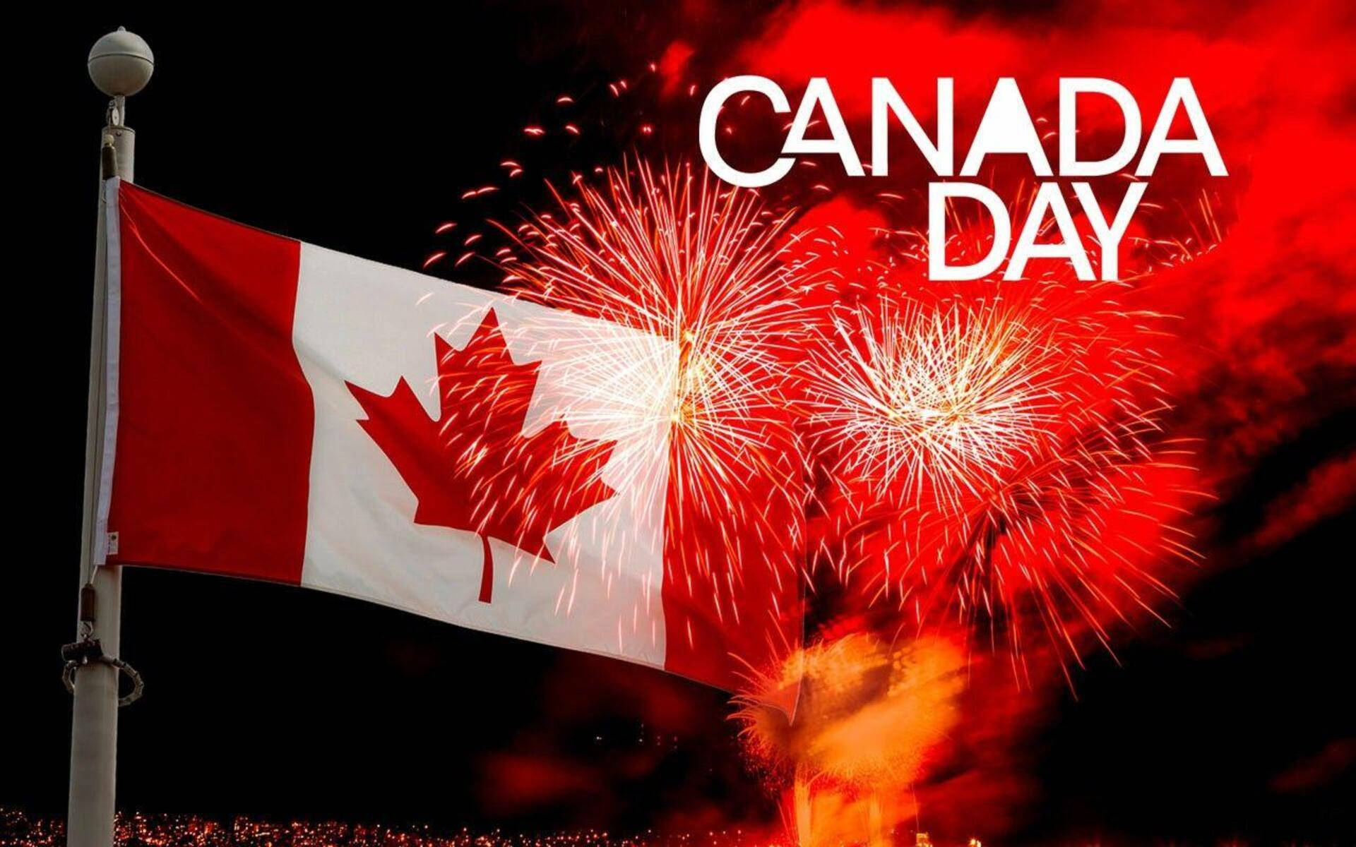 Canada Day 桌布 壁紙 — 加拿大國旗在夜空中自豪地飄揚，夜空綻放著鮮豔的紅色和金色煙火，慶祝加拿大日。